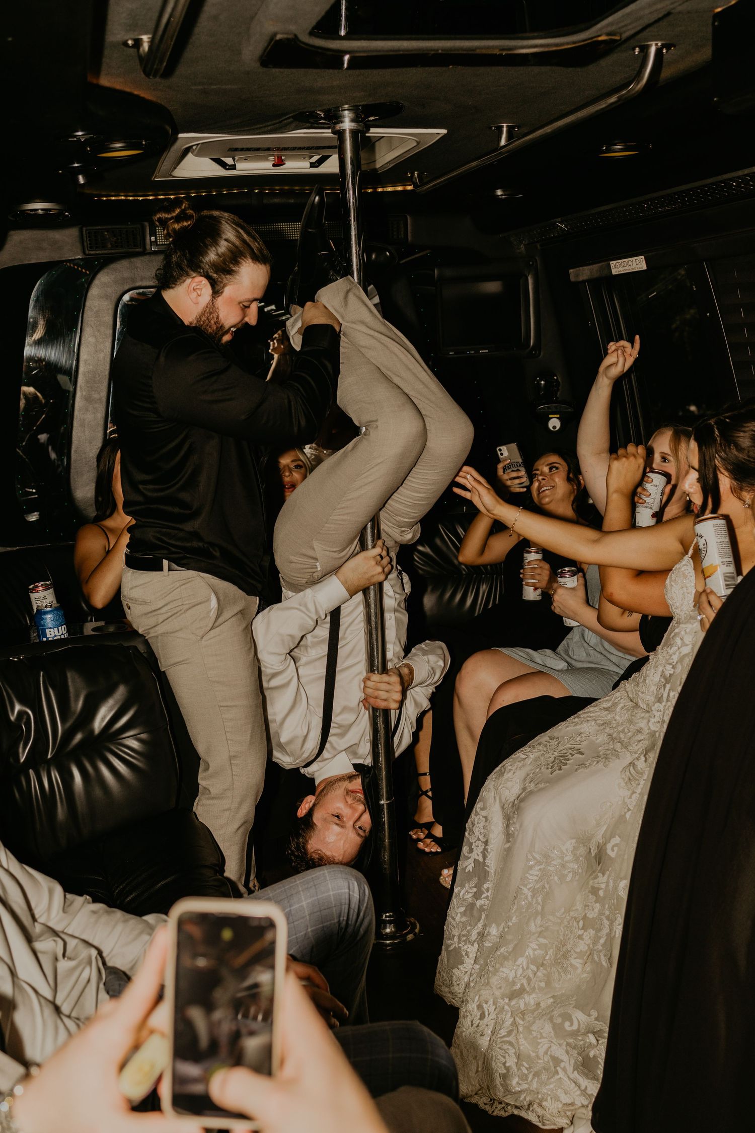 Party bus celebration shows guests dancing and taking photos during wedding festivities.