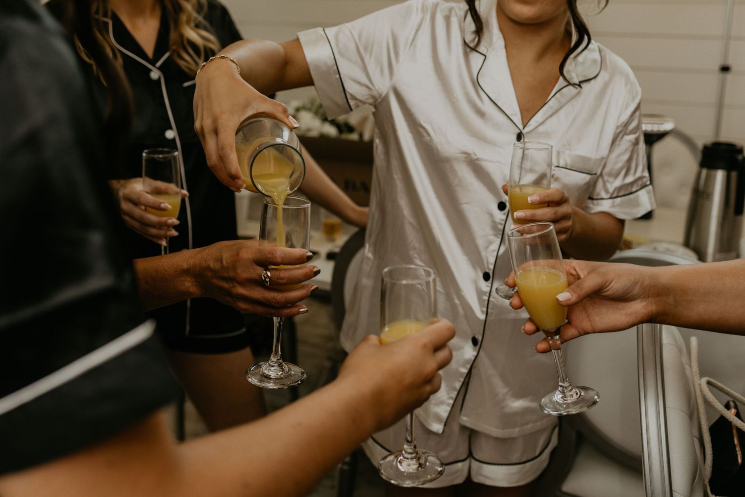 Hands pour champagne into glasses during a celebratory moment.