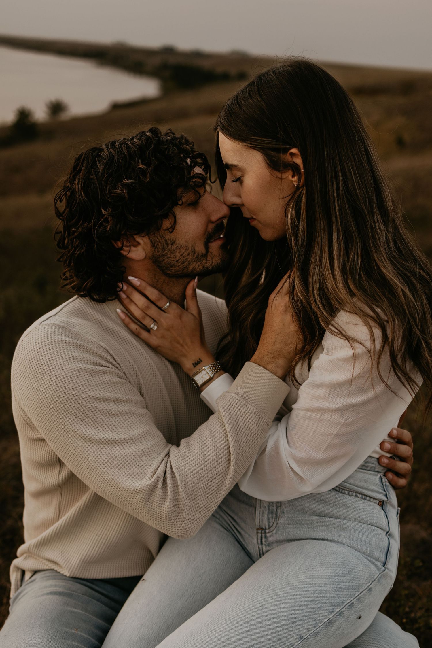 Intimate couple photographs on a hillside in neutral tones.