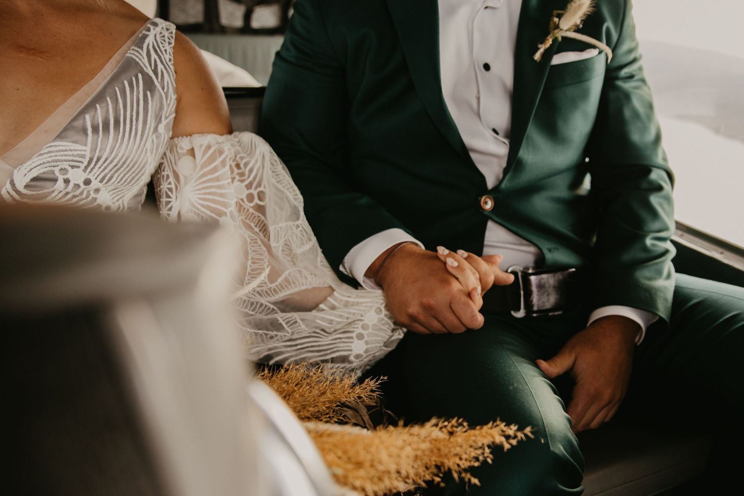 Close-up detail of formal attire and hands in aircraft seating.