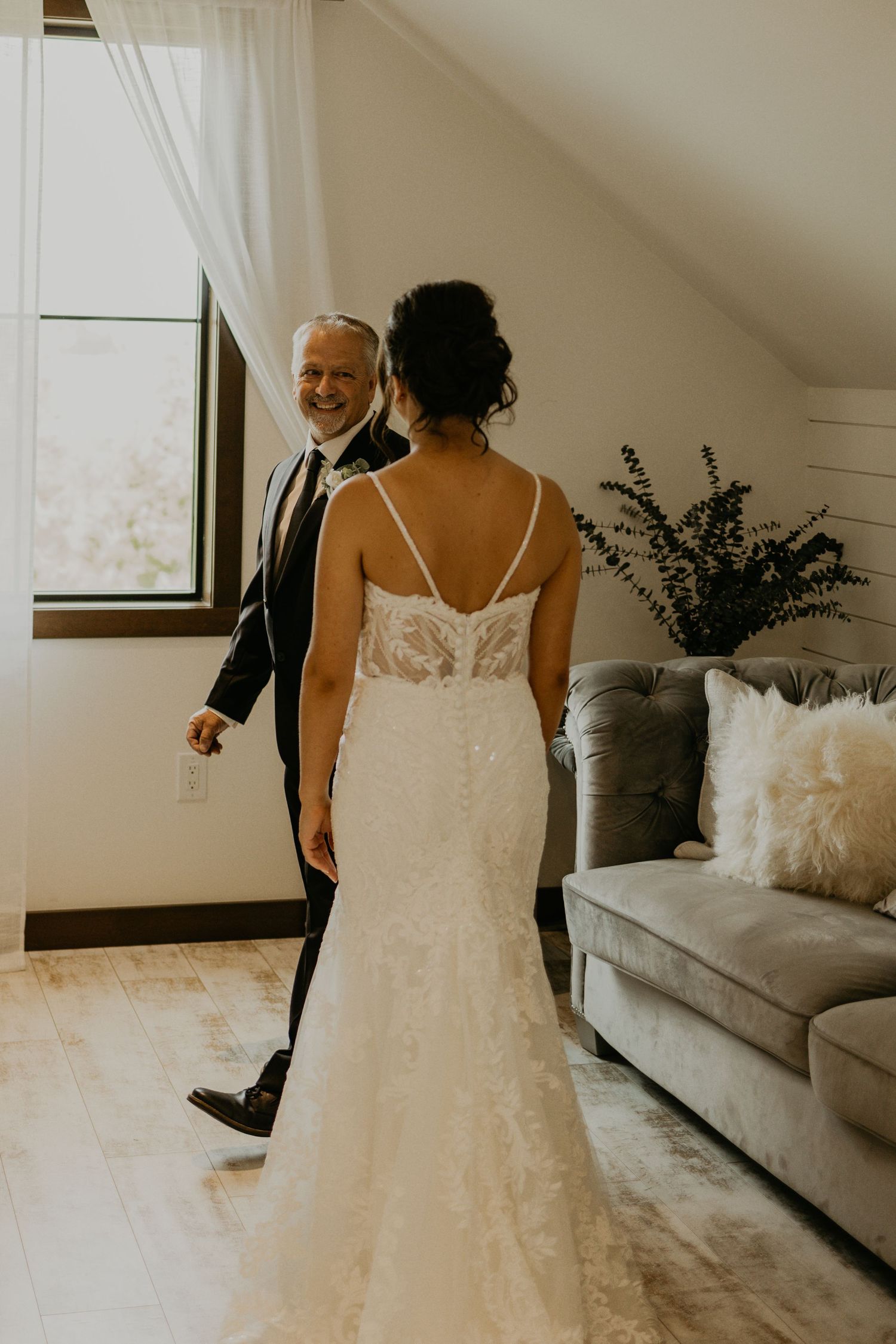A wedding dress silhouette stands elegantly in a sunlit room with modern decor.