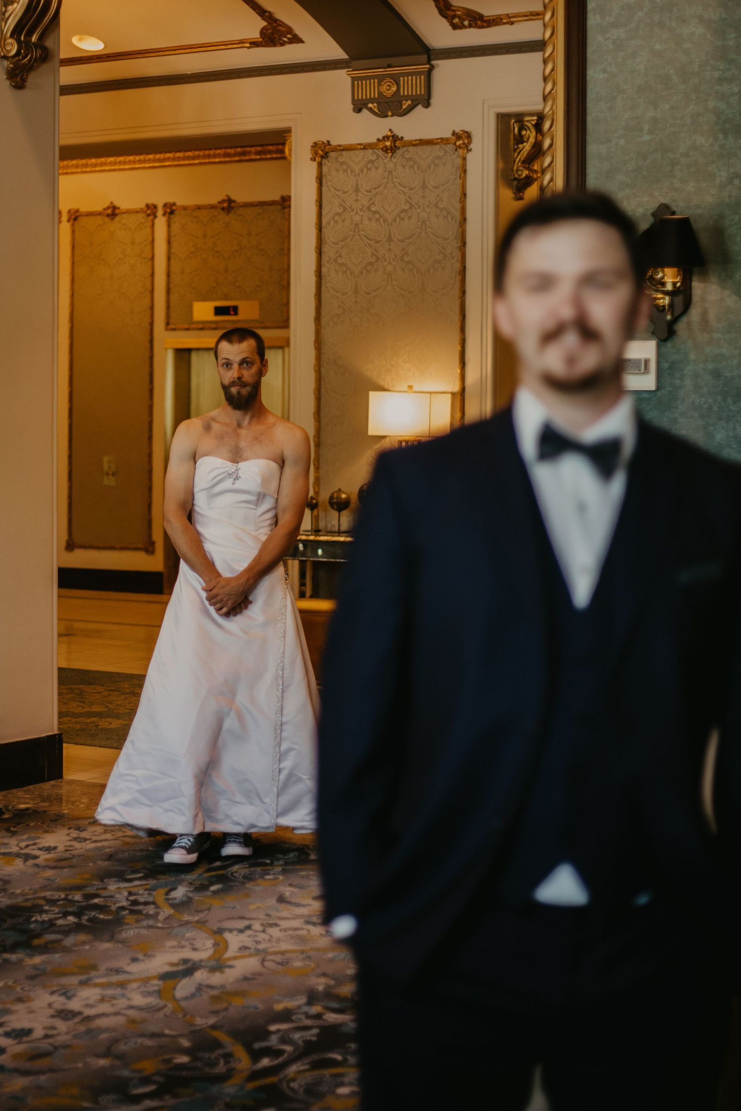 A wedding photo capturing a candid moment in an ornate indoor venue with vintage details.