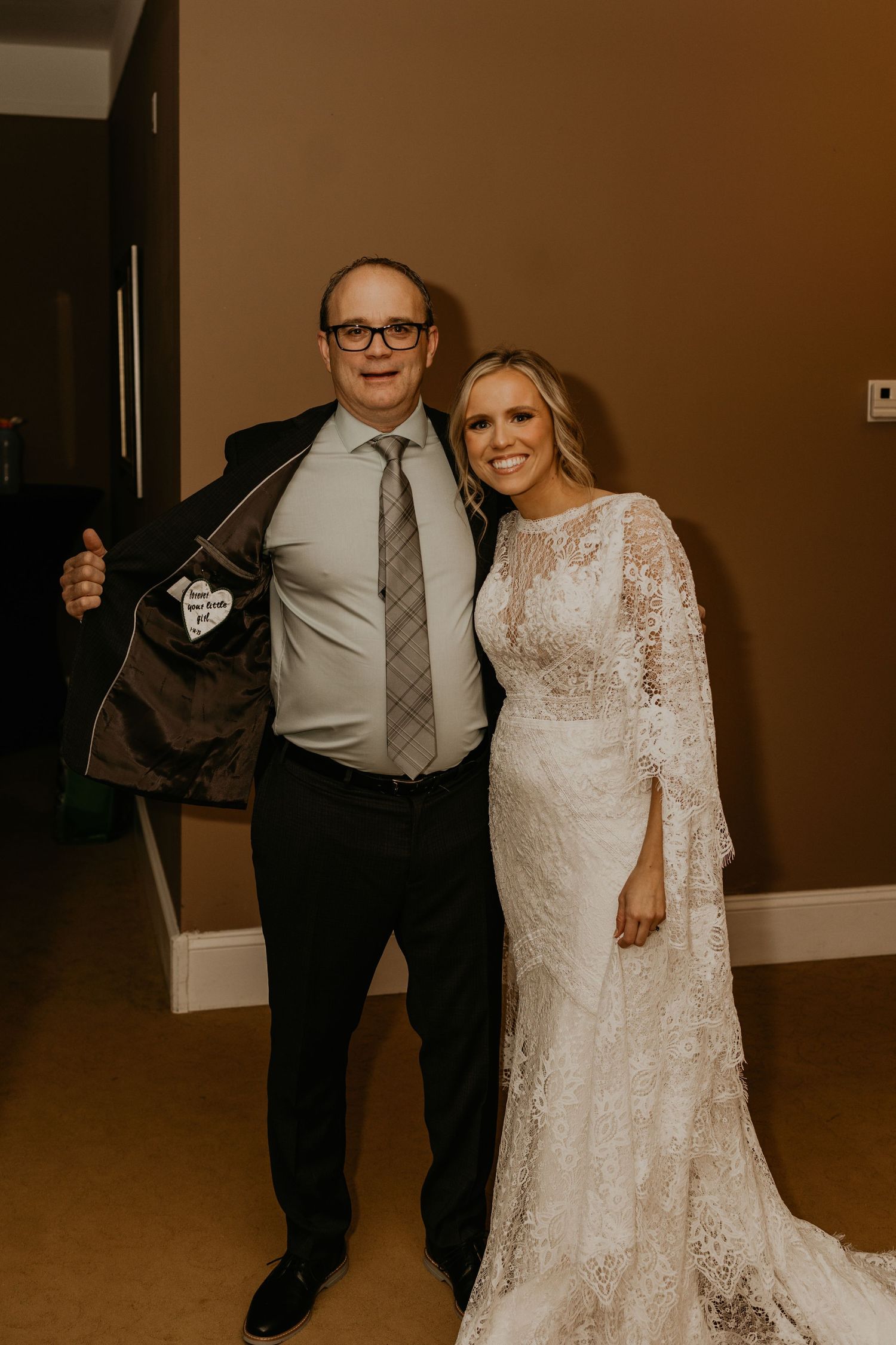 A touching moment between two people posing in formal wedding attire.