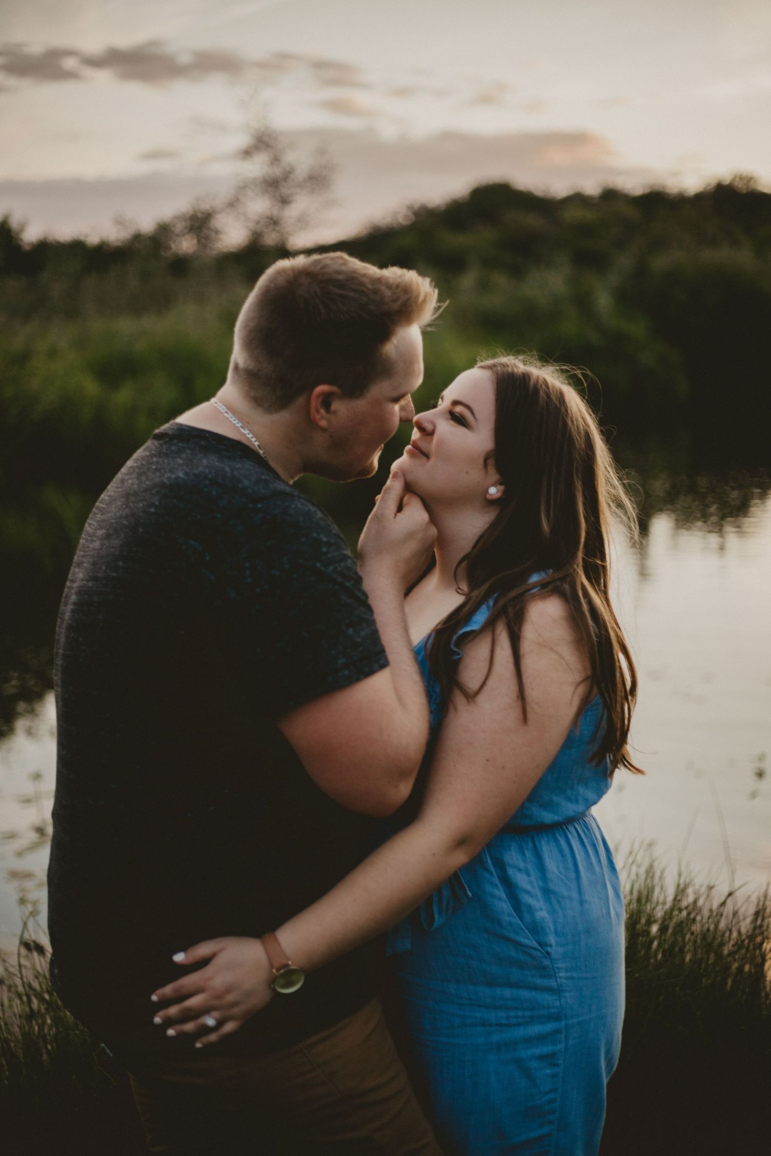 Romantic couple moment captured by a lake at sunset.