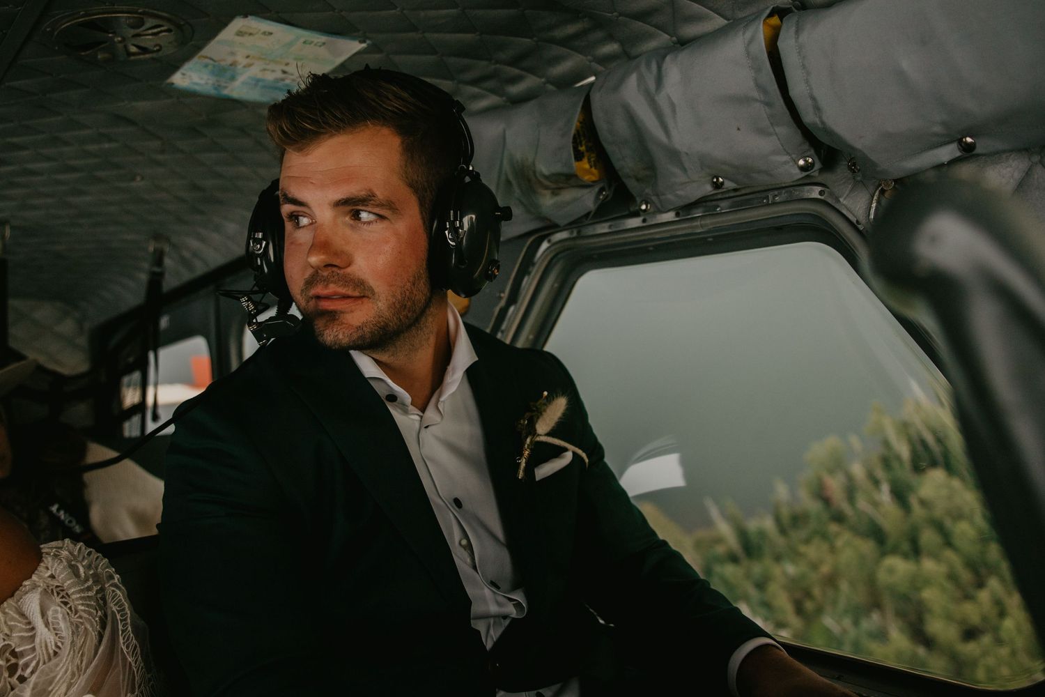 Interior view of passenger in small aircraft cabin during forest flight.