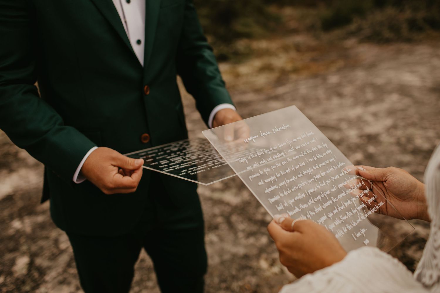 Close-up of handwritten wedding vows being exchanged during outdoor ceremony.