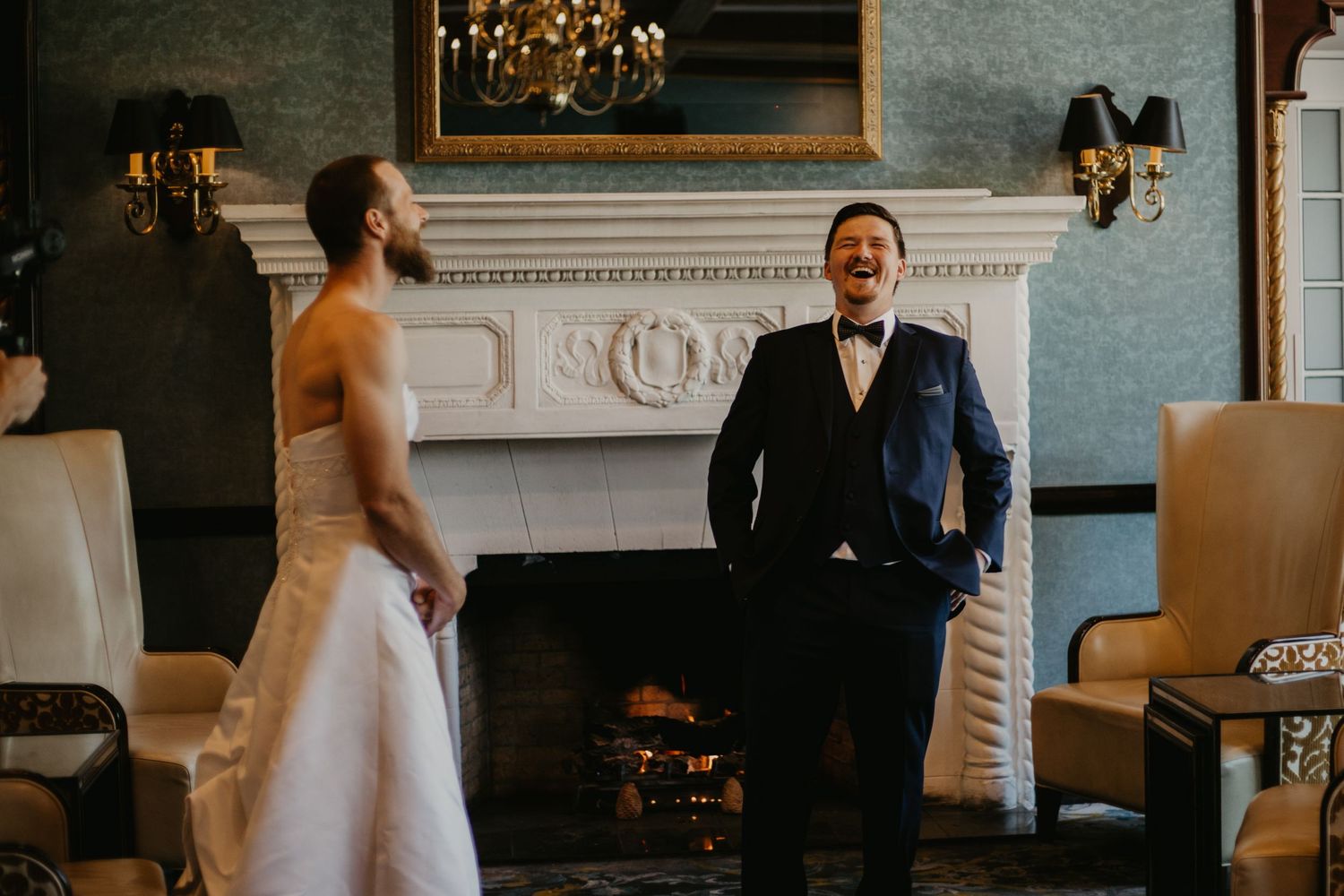 An intimate wedding scene in a room with elegant decor and a dramatic fireplace setting.