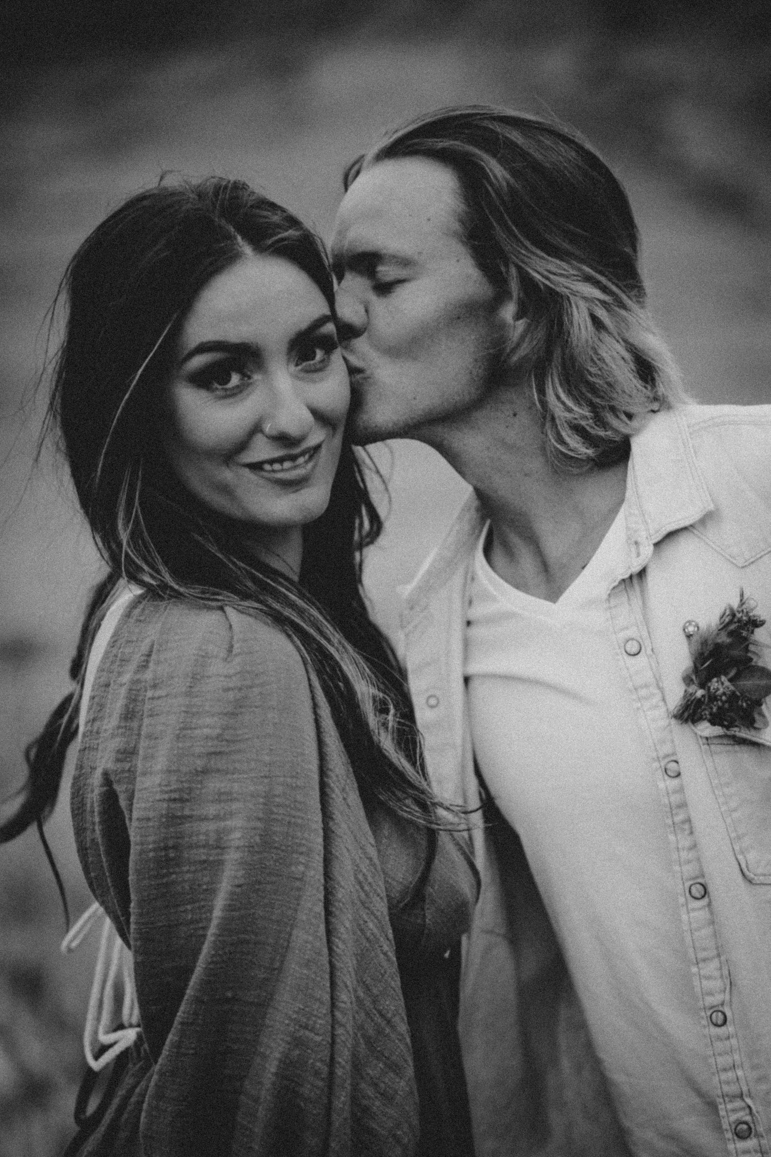 Black and white portrait of an affectionate couple in casual attire.