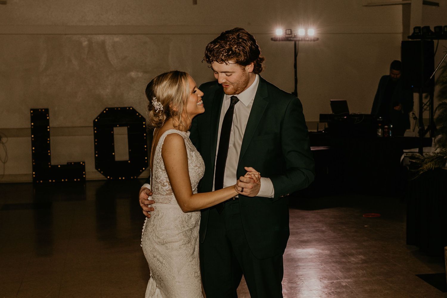 A tender moment during a wedding dance as couple sways in an intimate indoor venue.