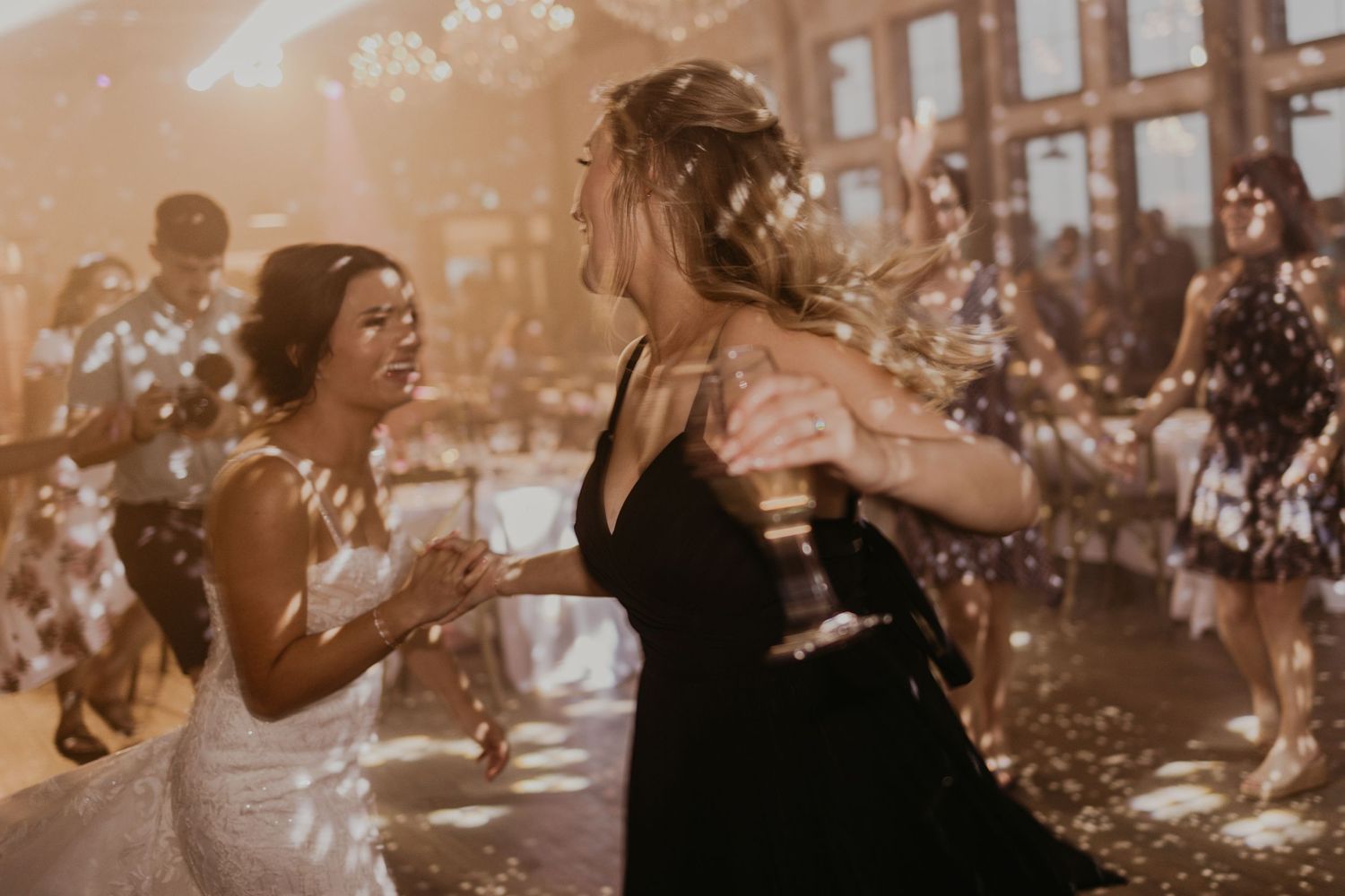 Happy dancing at wedding reception with sparkles and warm lighting.
