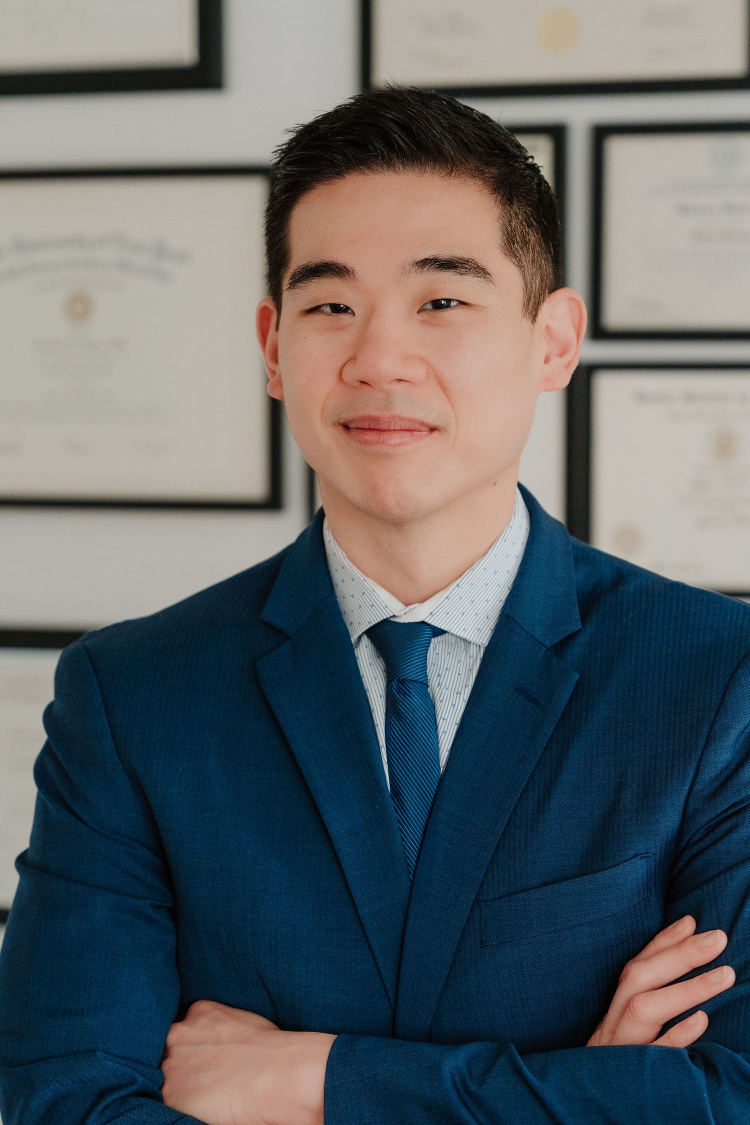 Professional headshot series showing person in navy blue suit and tie against white background.
