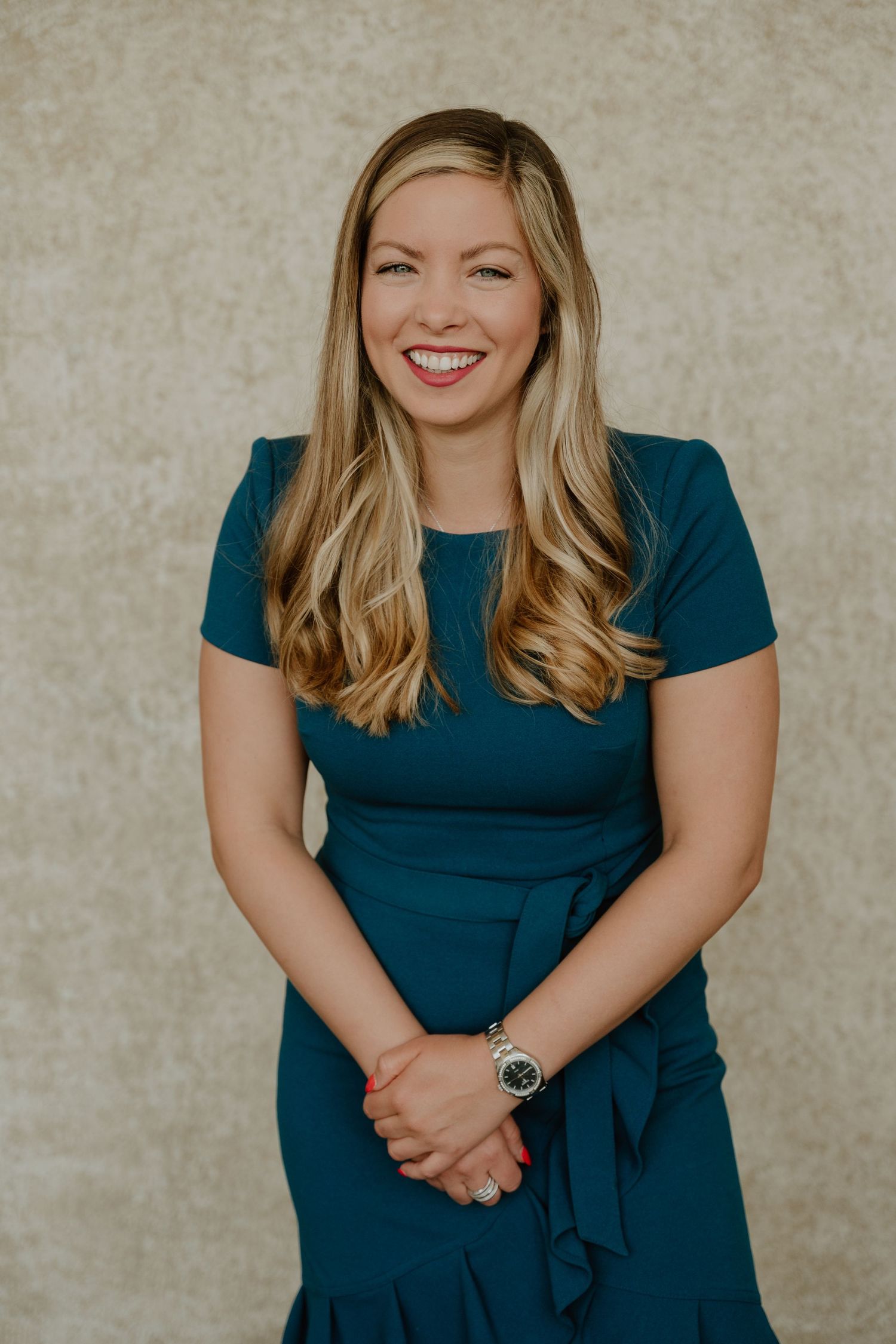 A series of professional portraits showing someone in a teal blue dress against a neutral beige backdrop.