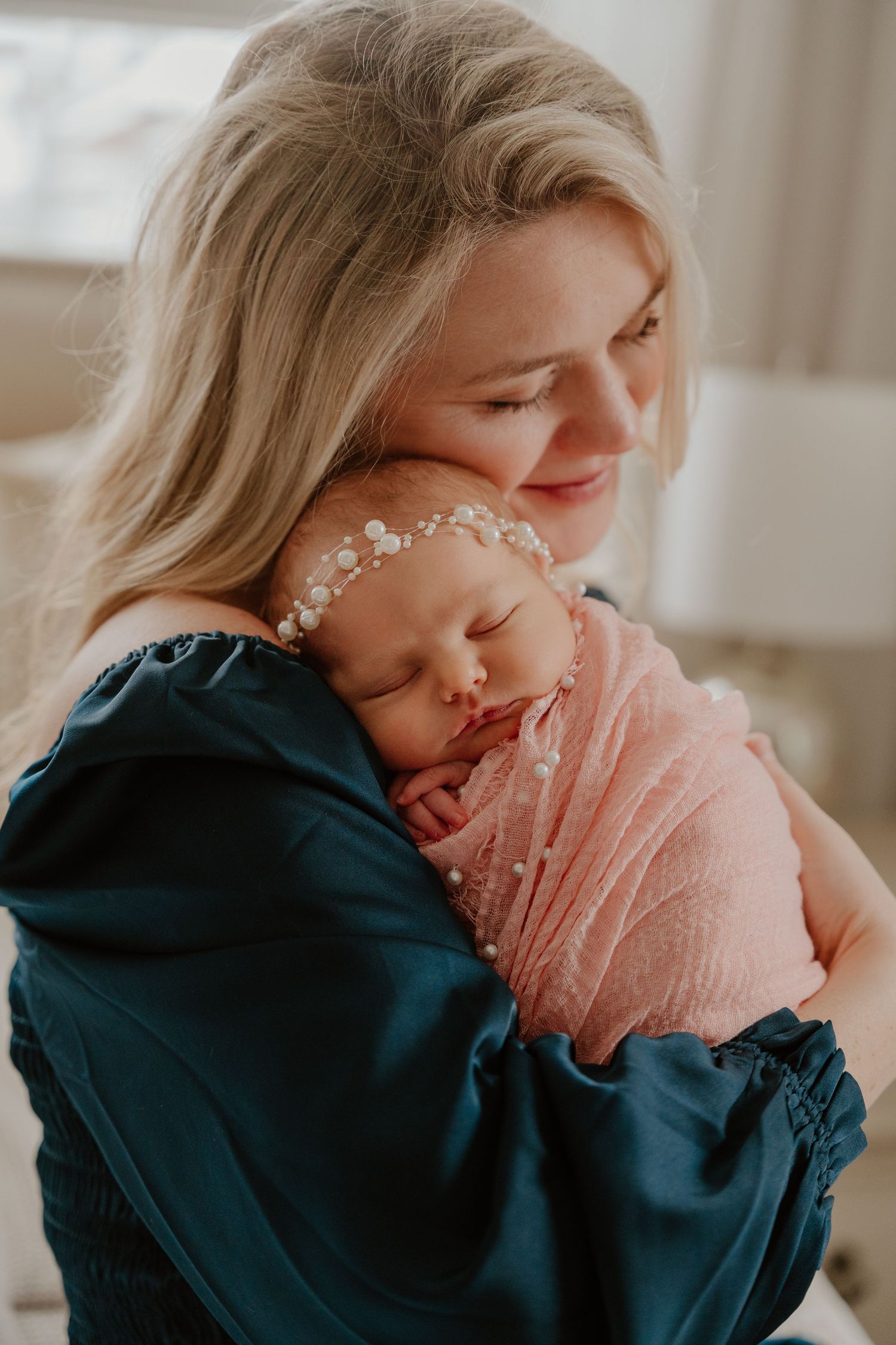 A tender moment captured in soft lighting shows gentle affection and delicate floral hair accessories.
