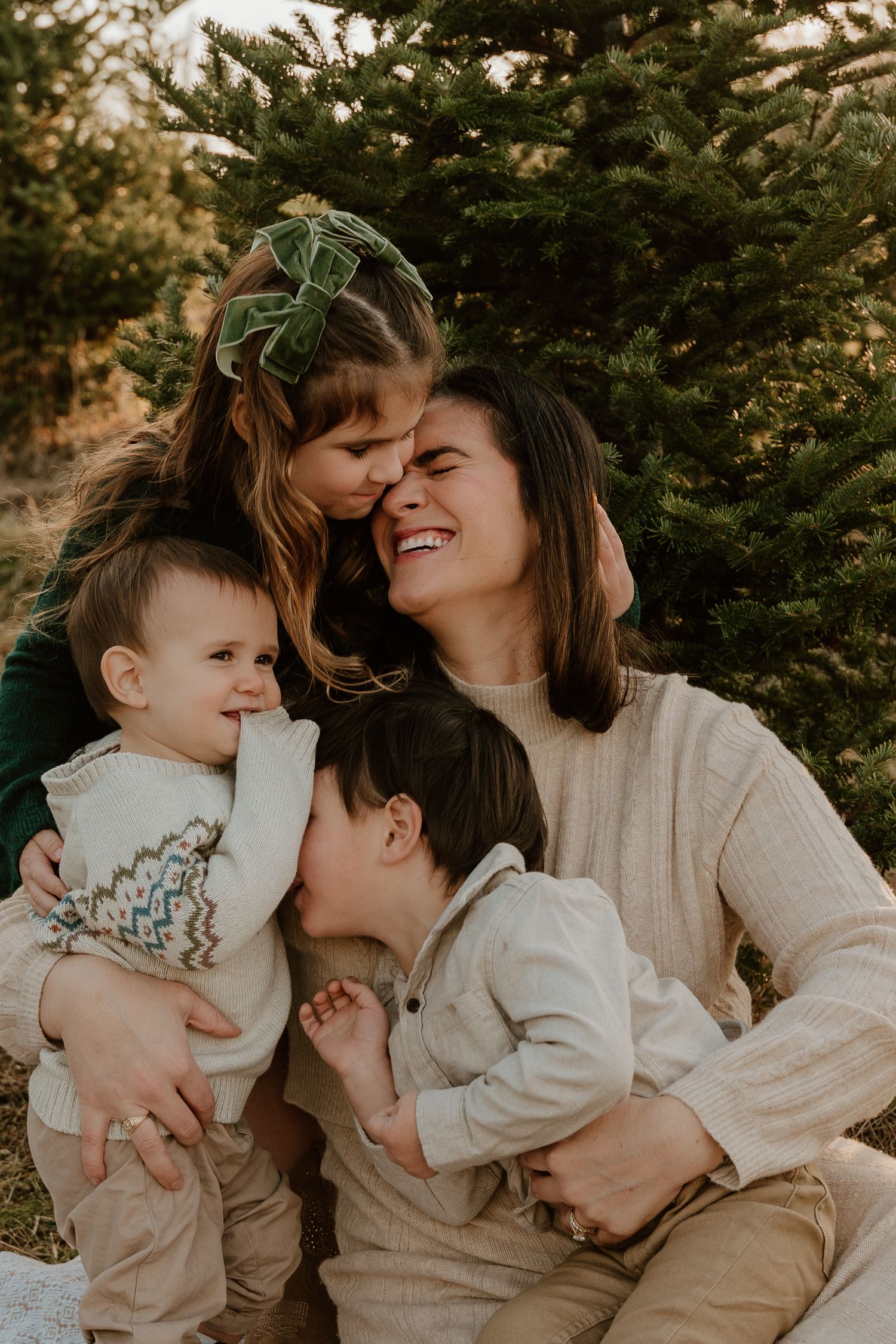 Family wearing neutral tones shares intimate candid moments together during outdoor photo session South of Pittsburgh at sunset.