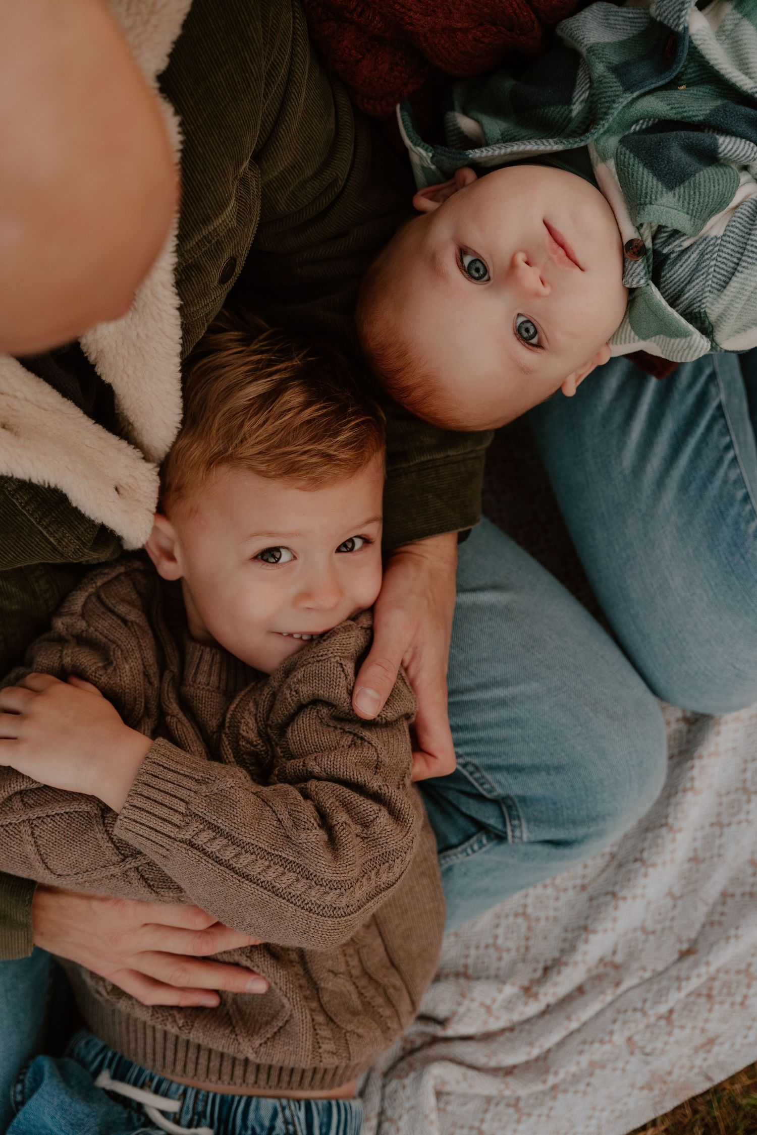 A series of candid lifestyle photos showing tender moments between parent and child on a textured blanket.