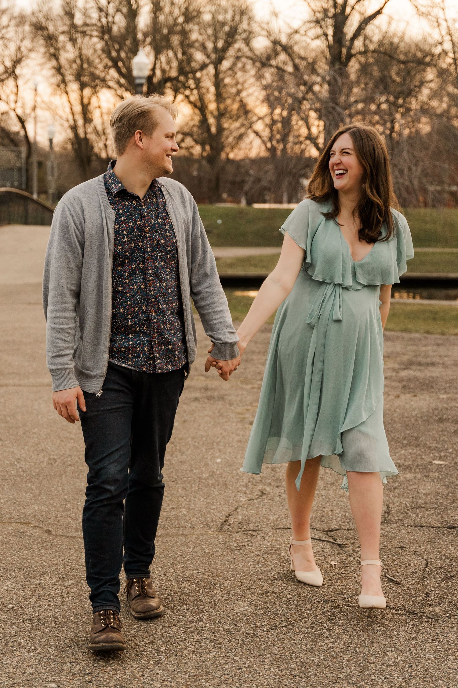 Expecting Couple walking hand in hand during golden hour