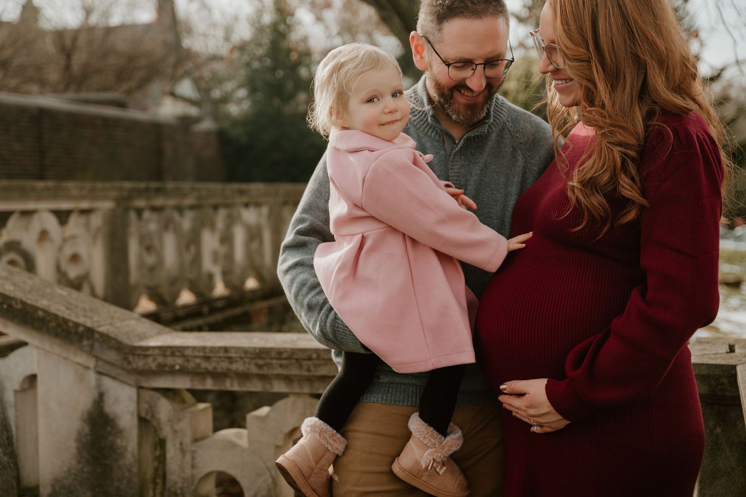 Family enjoying outdoor portrait session in natural setting wearing coordinated fall colors.