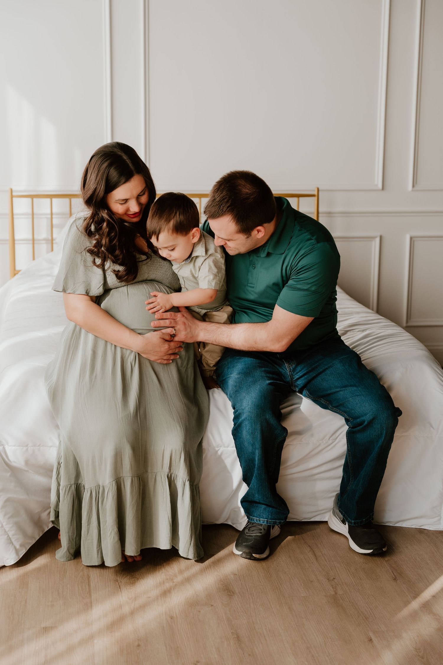 Family sitting together on floor against white wall showing progression of playful poses and interactions.