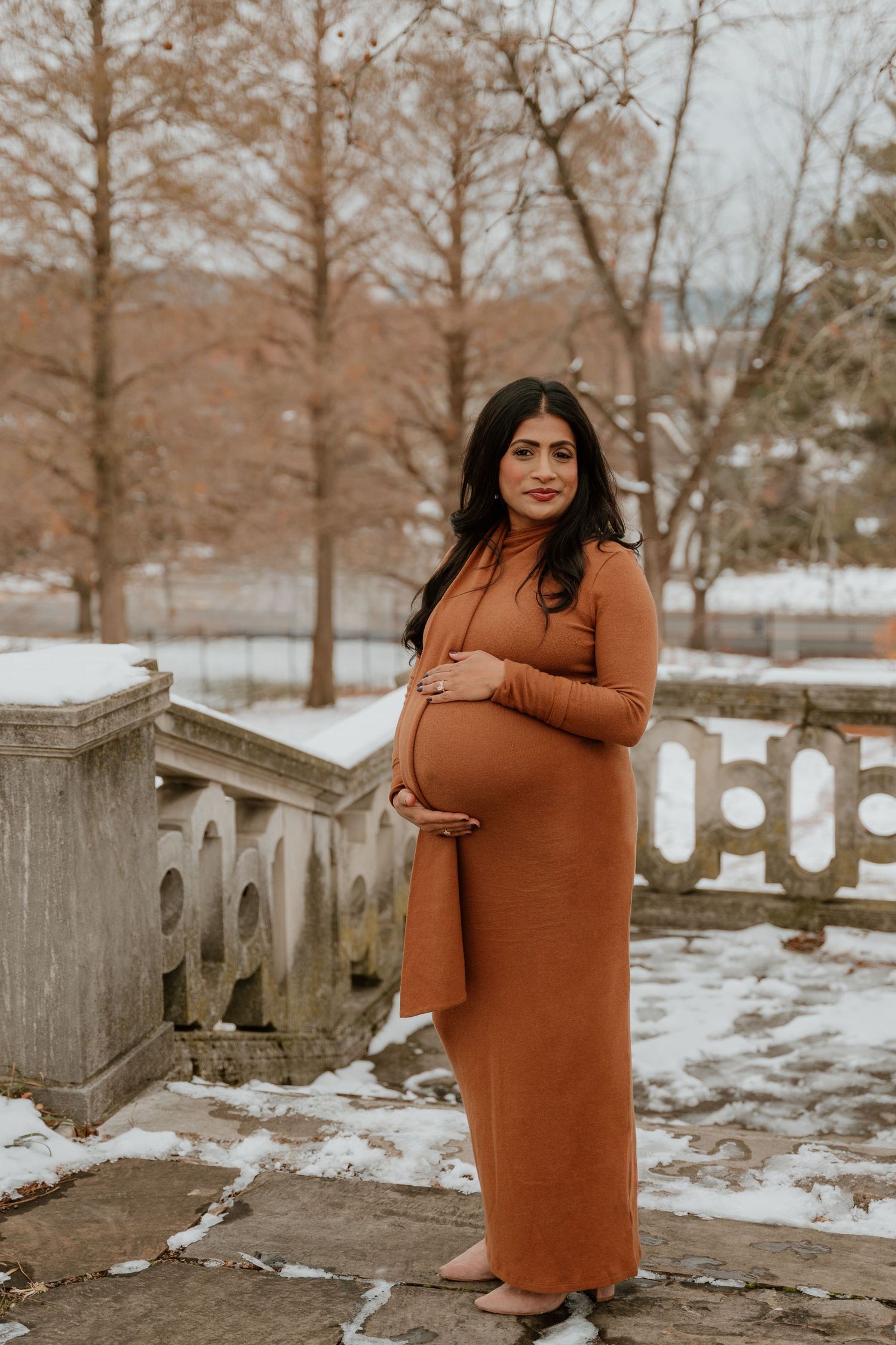 A series of outdoor winter portraits showing someone in a cozy rust-colored sweater dress posing near a wooden fence.