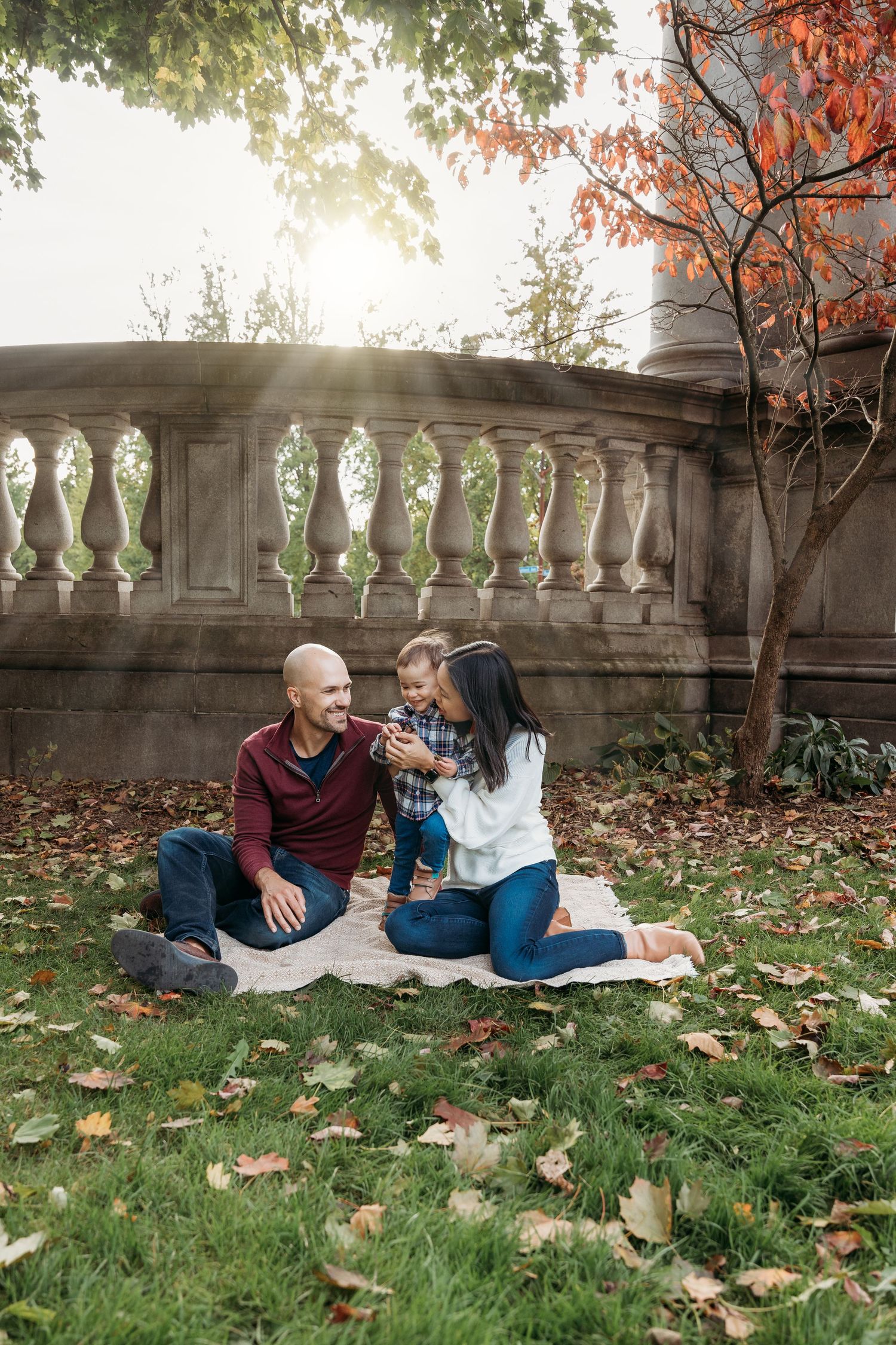 Family of three Snuggled on Blanket in Fall