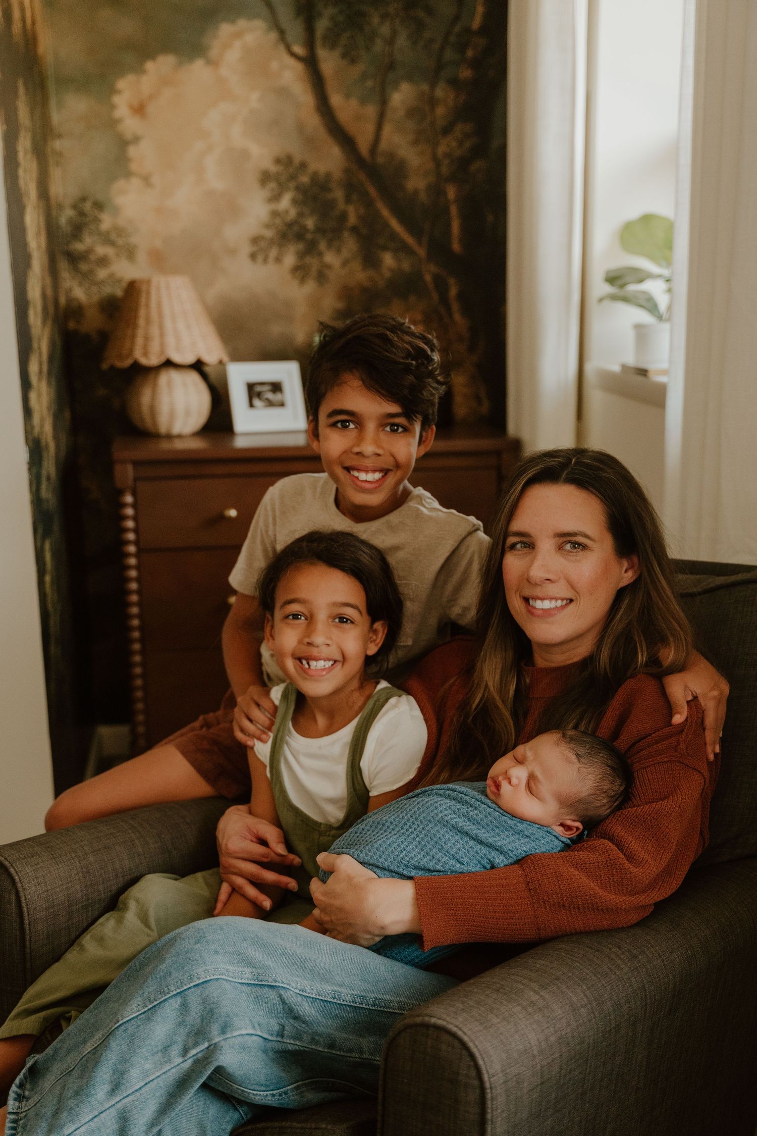 A group relaxes together on a couch in a warmly lit room, sharing joyful moments and laughter.