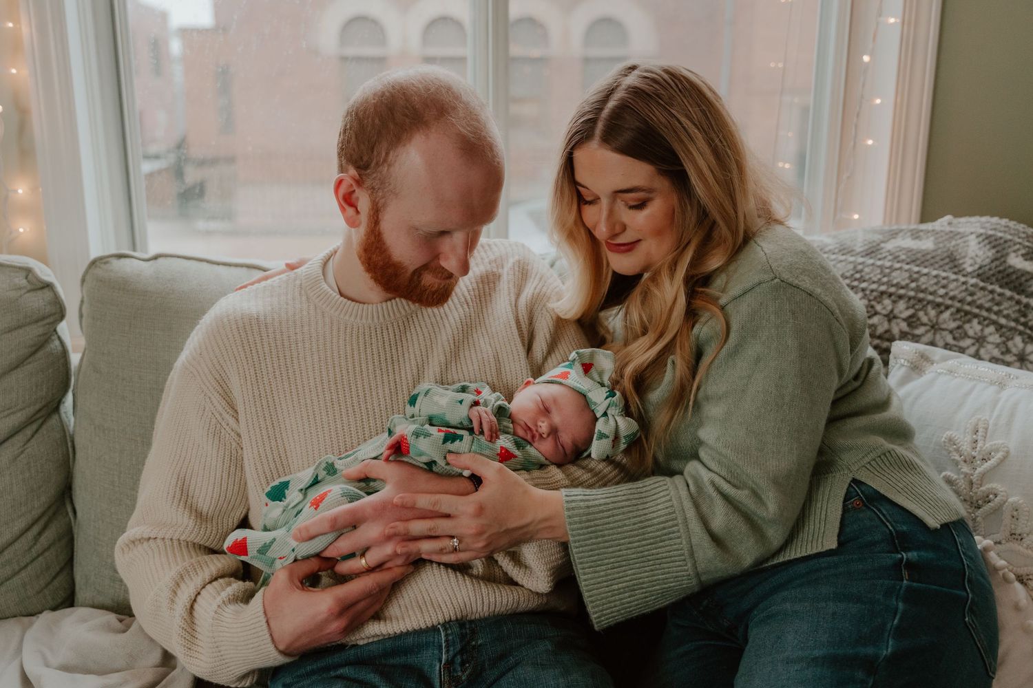 Parents in cozy sweaters share tender moments with their newborn baby in a series of intimate home photos.