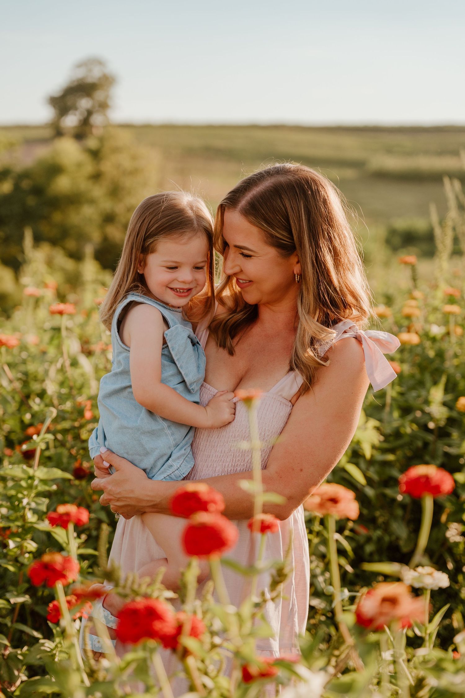 Family enjoying tender moments in a field of vibrant red poppies during golden hour.
