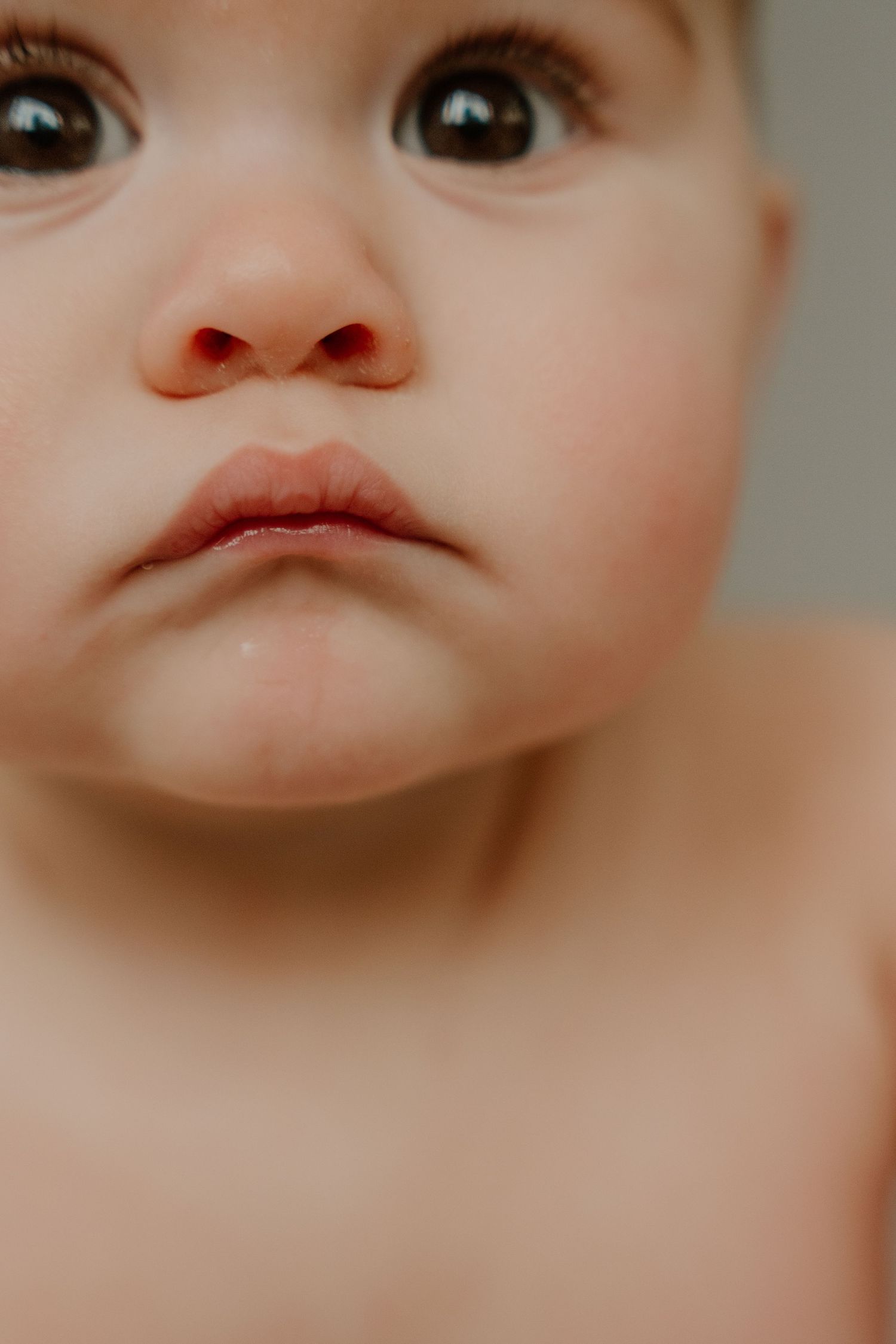 Close-up portrait of a baby's face showing adorable pouty lips and expressive eyes.