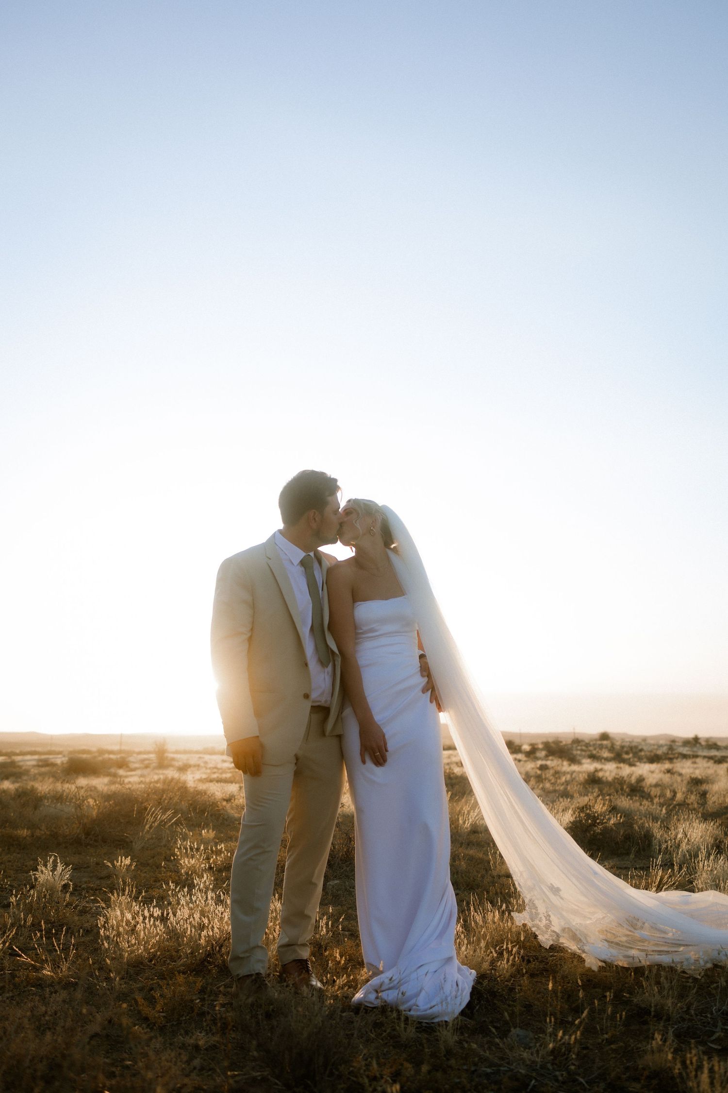 Bride and groom sharing a tender moment in natural landscape at sunset, Western Cape wedding photographer
