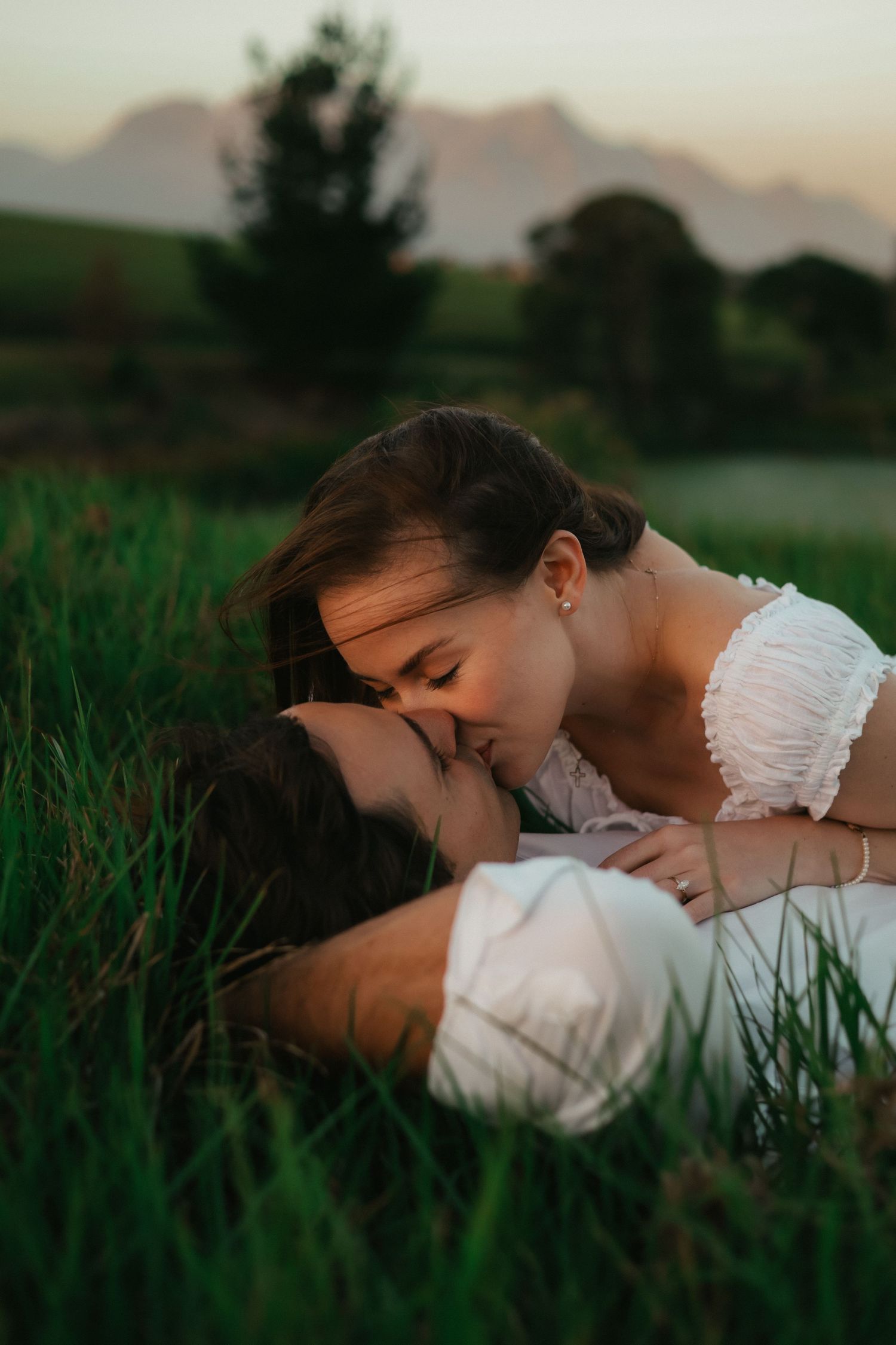 Couple lying in grass at sunset in Garden Route nostalgic wedding photography