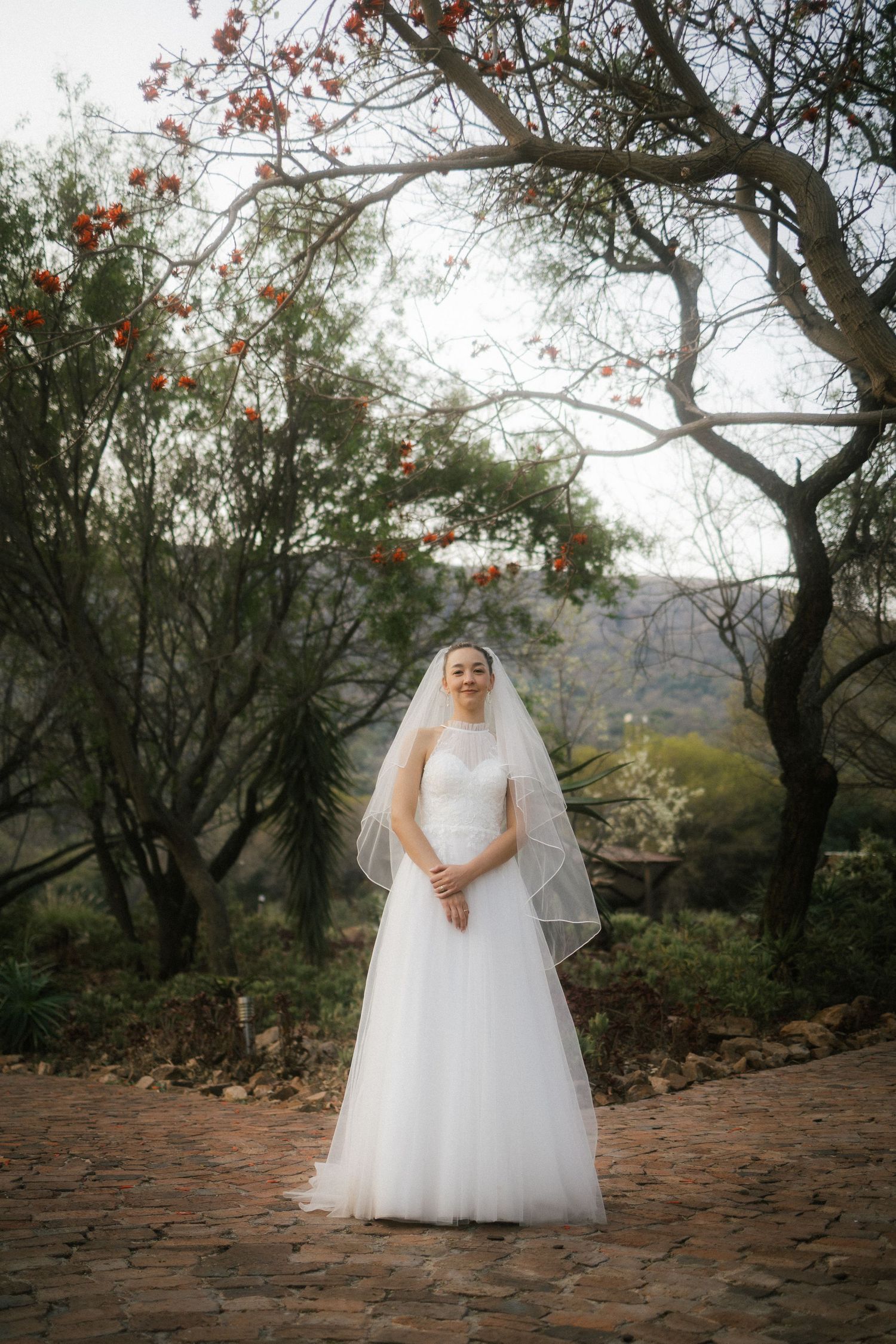 Bride in white wedding dress standing on stone path in Garden Route engagement shoot