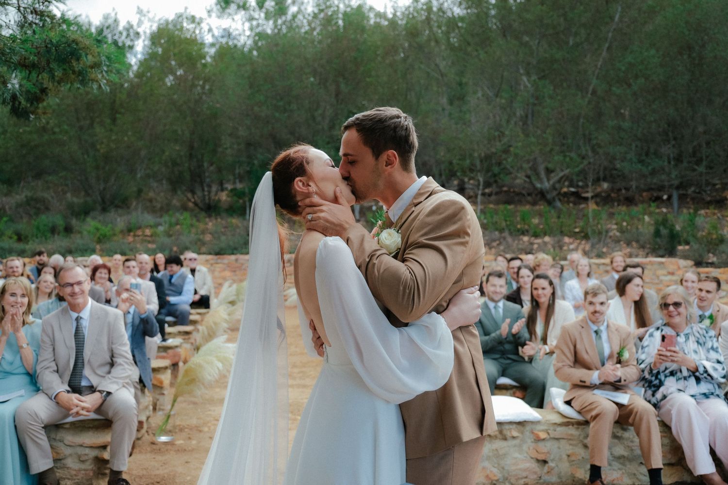 Bride and groom kissing at outdoor wedding ceremony in South Africa