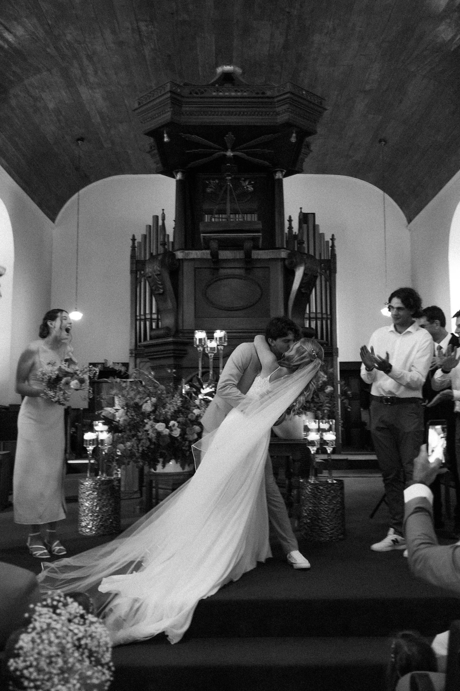 Bride and groom kissing at altar during wedding ceremony in church, Garden Route wedding videographer
