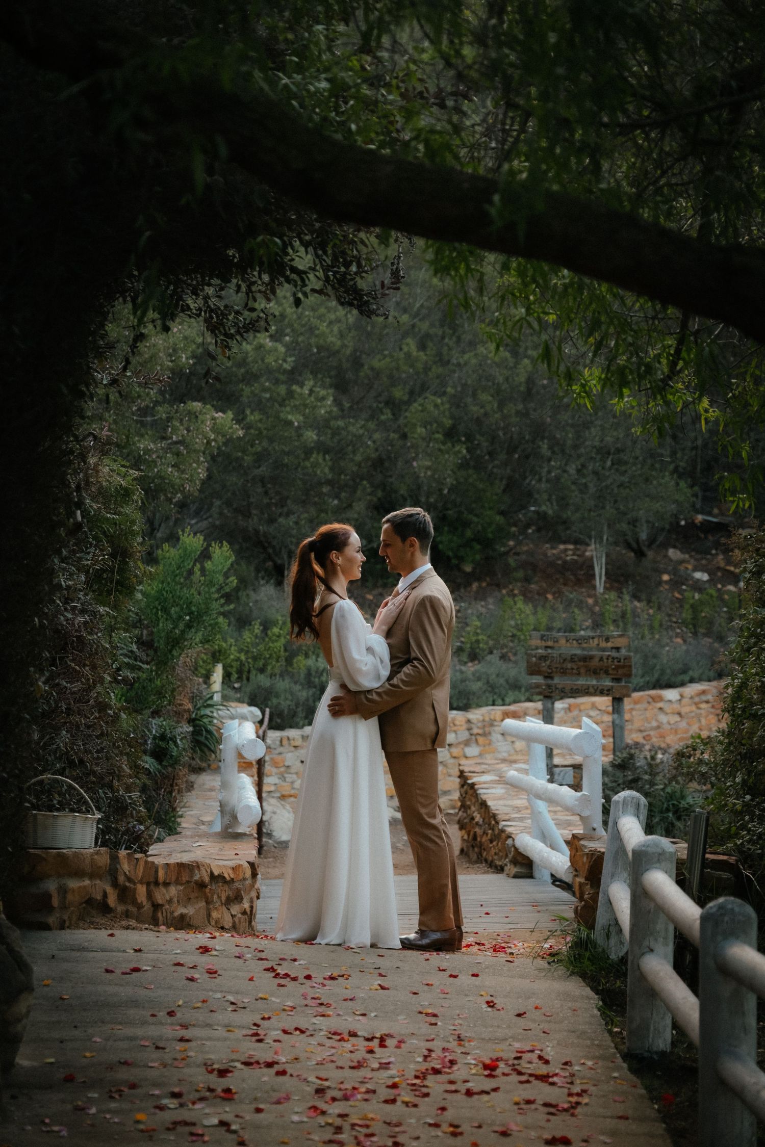 Bride and groom embracing on a rustic pathway in Garden Route wedding videography setting