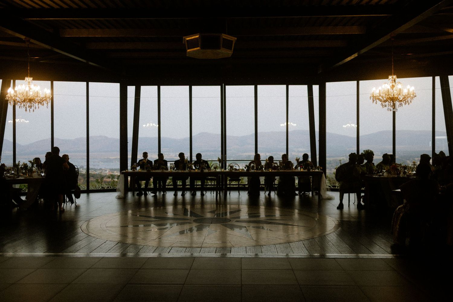 Wedding reception with guests at long tables and mountain views in Garden Route venue