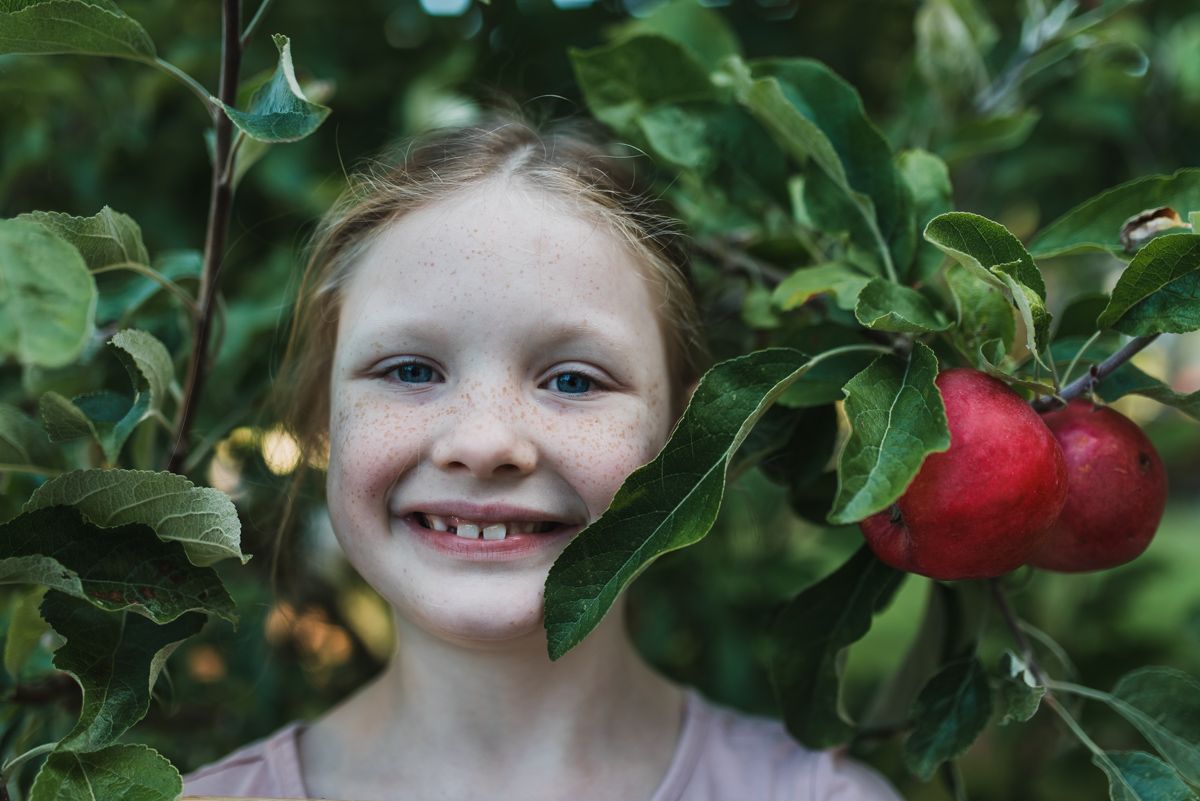 Girl standing in apple tree