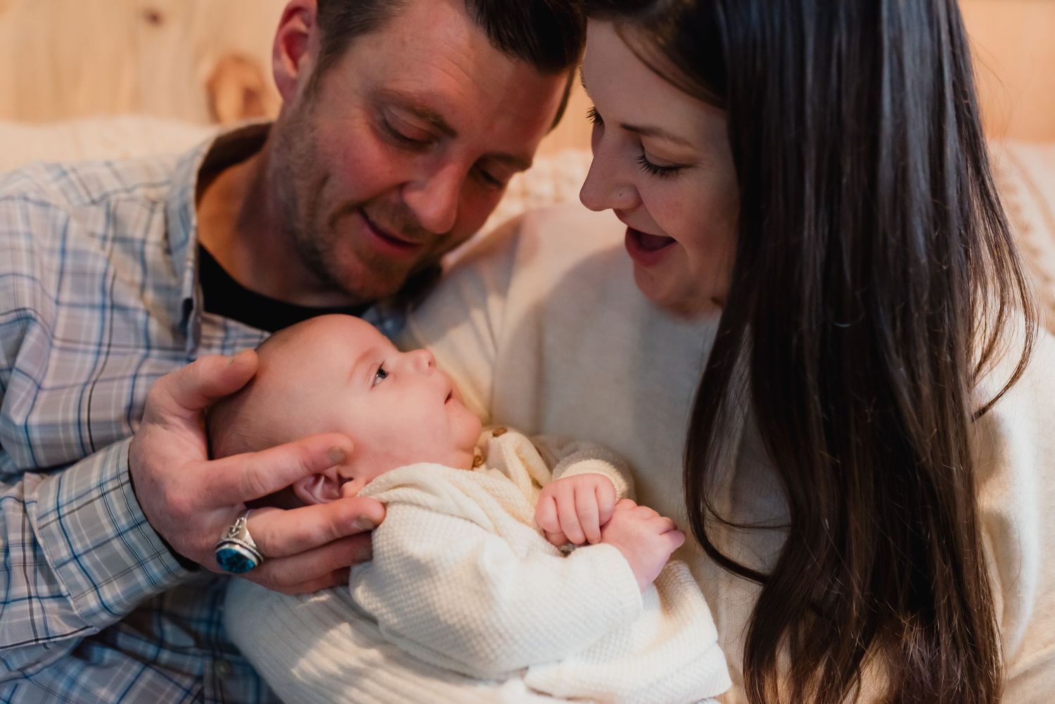 A couple shares tender moments with their newborn baby in a series of intimate family photos.