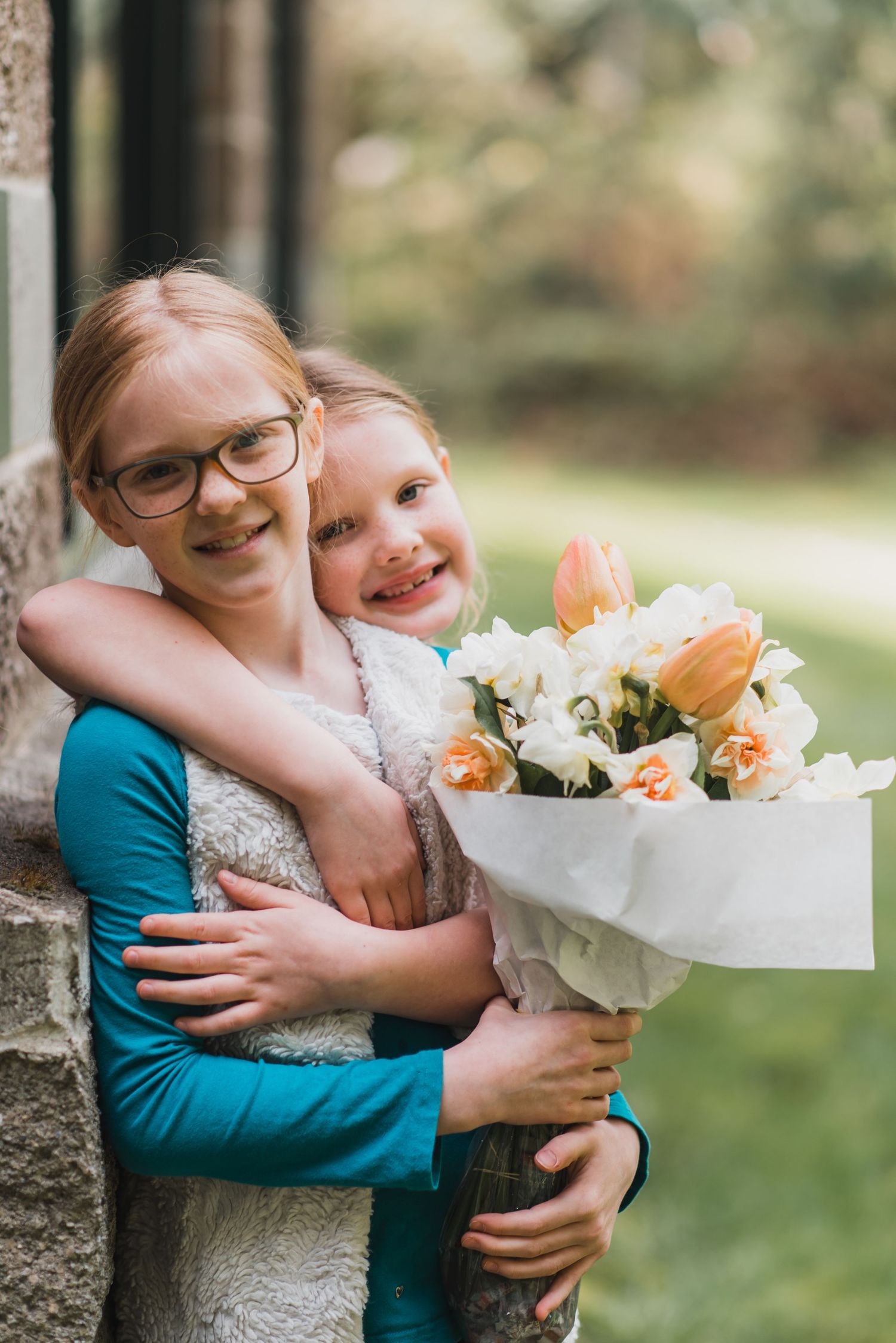 Candid outdoor photography showing genuine affection and laughter while holding fresh flowers.