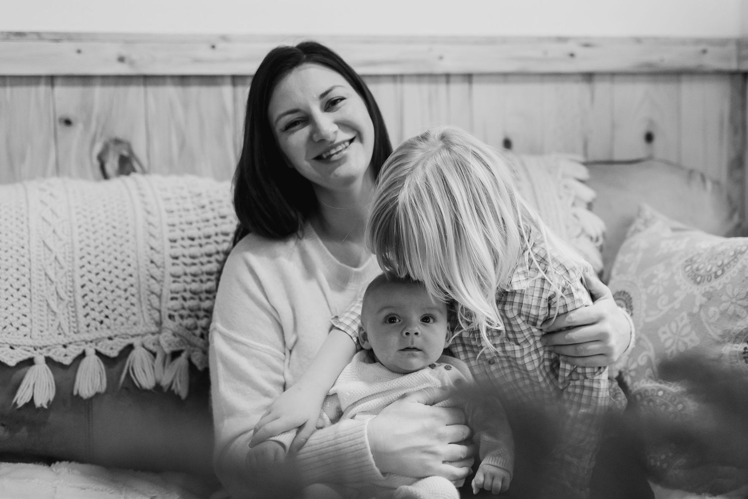 Black and white photo series showing intimate family moments of mother and child bonding at home.