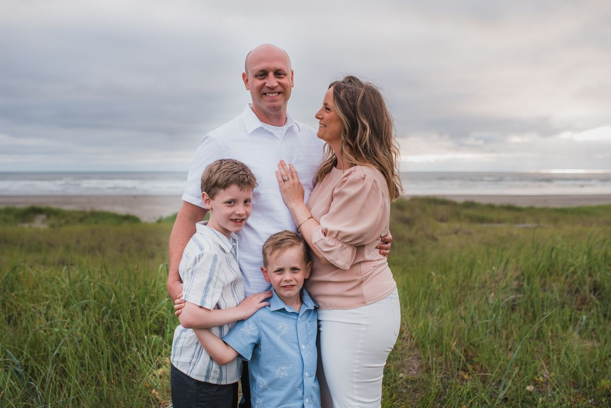 Family portrait session in a natural field setting at dusk.