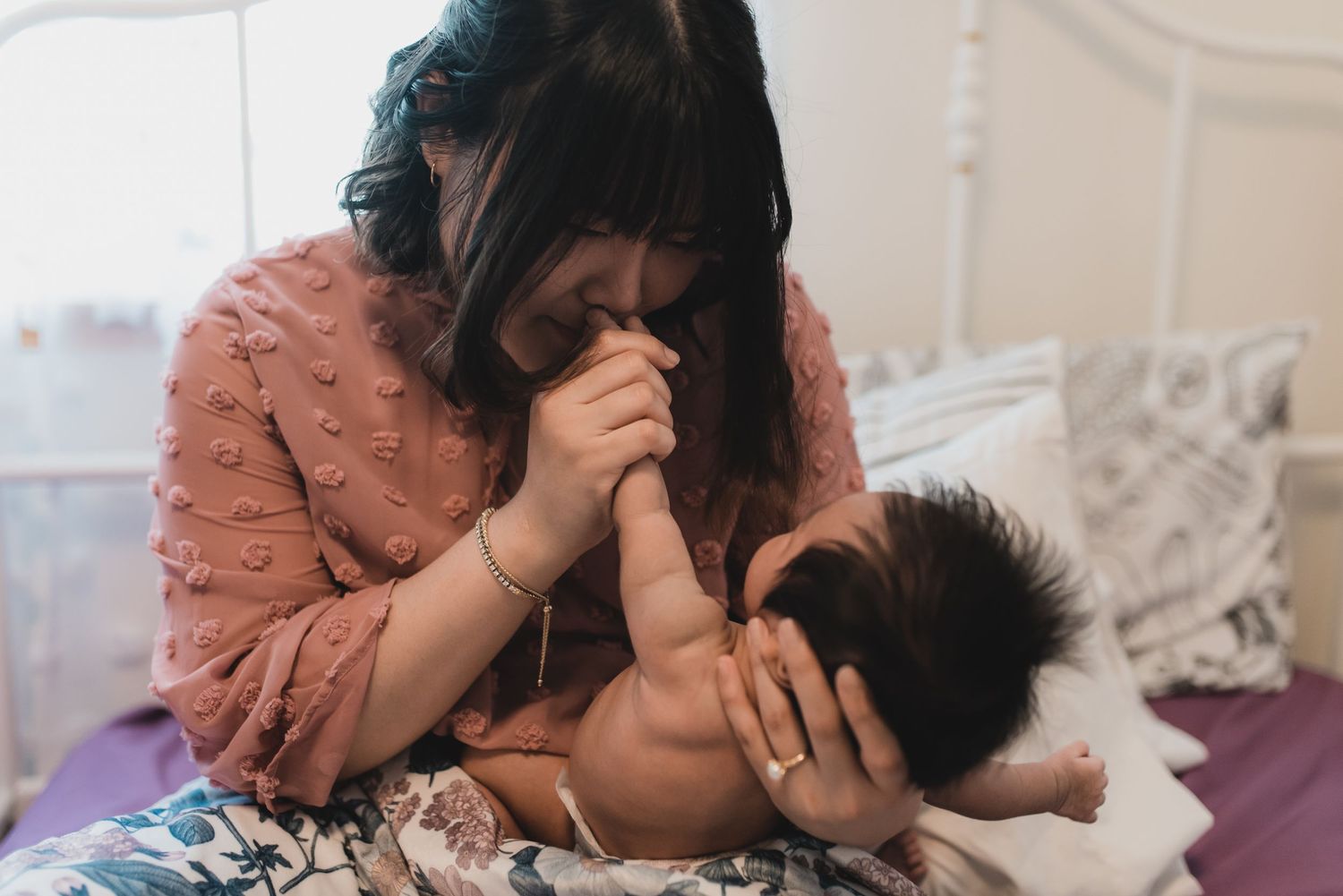Intimate indoor family moment captured on soft bedding.