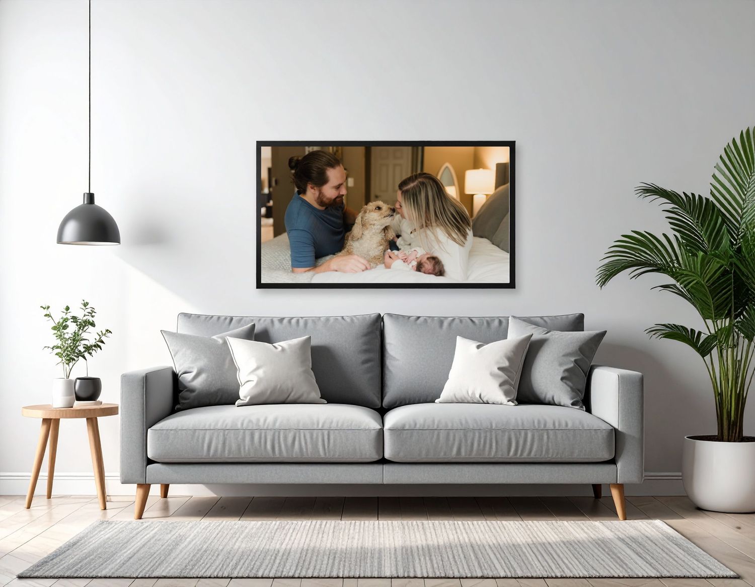 Large wall portrait of a family on the living room wall above a couch in a modern gray living room with plants.