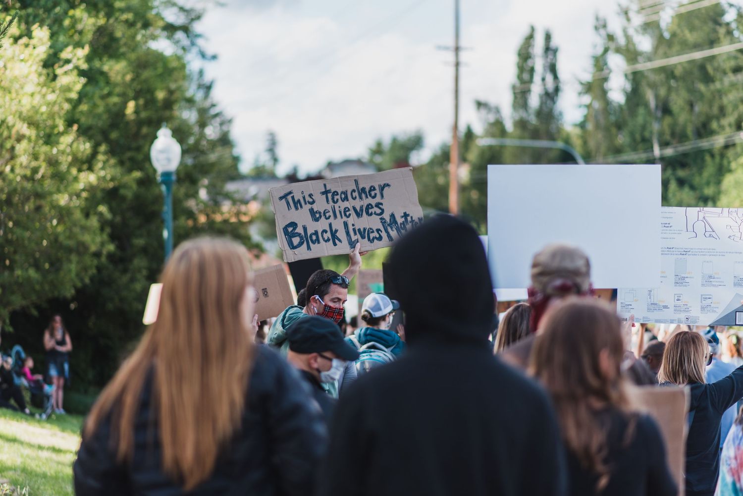 Black Lives Matter Mukilteo sign This Teacher Believes Black Lives Matter held by supporter in the street
