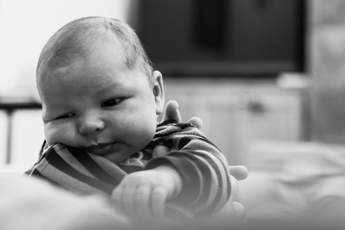 baby boy in striped onesie being held