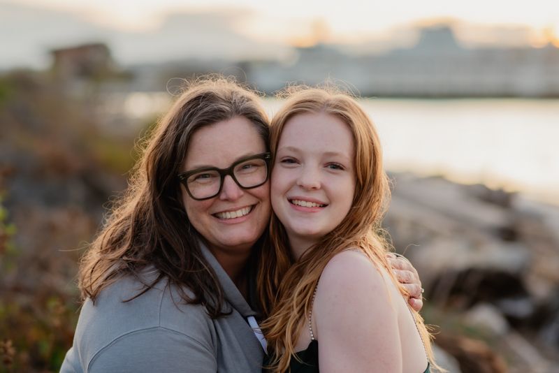A series of outdoor portrait photos taken at sunset showing people embracing and smiling along a rocky shoreline.