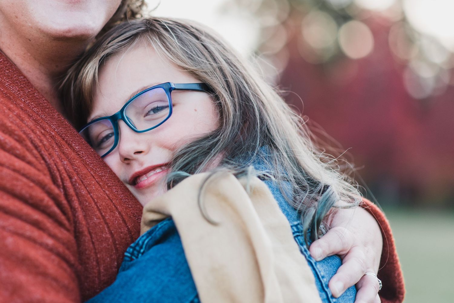 daughter wearing glasses, snuggled close to her mom