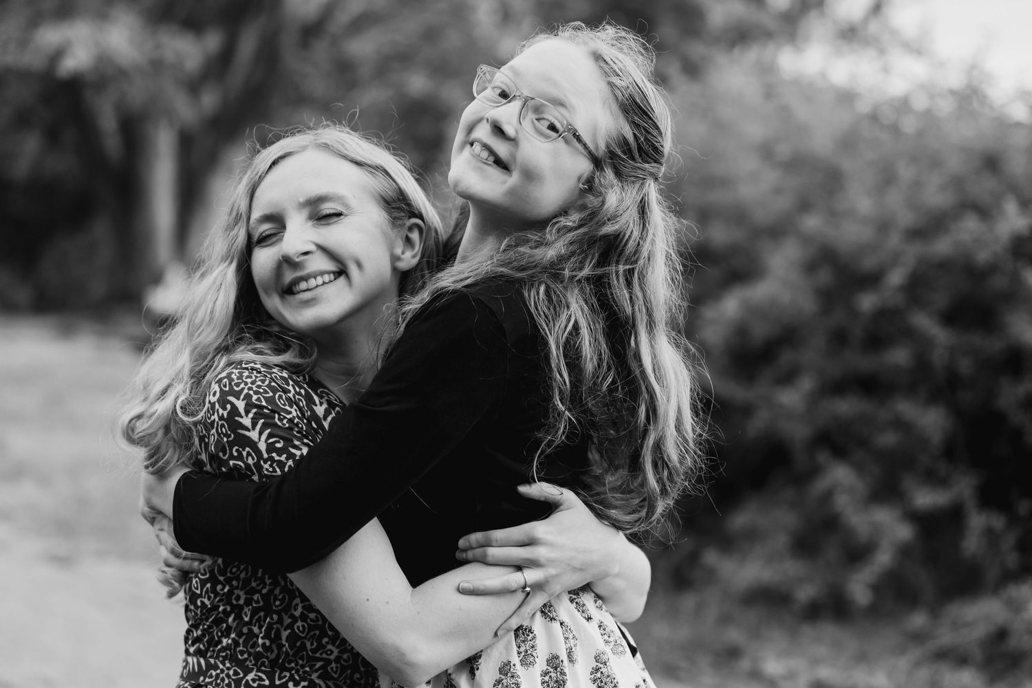 Black and white collage of joyful candid moments showing people embracing and laughing together outdoors.