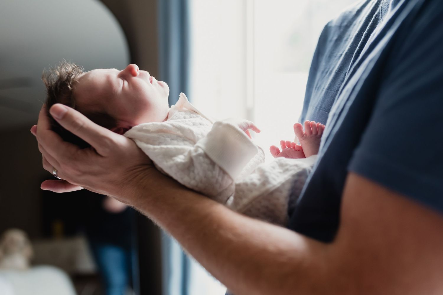 A series of images showing hands holding and examining a small white newborn baby diaper from different angles.