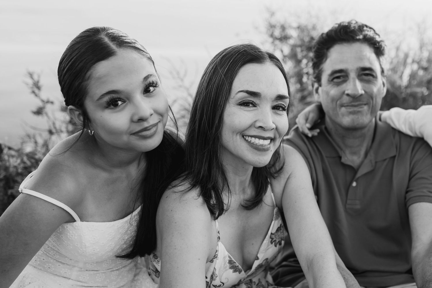 Black and white family photo collage showing candid moments and smiles in casual outdoor settings.