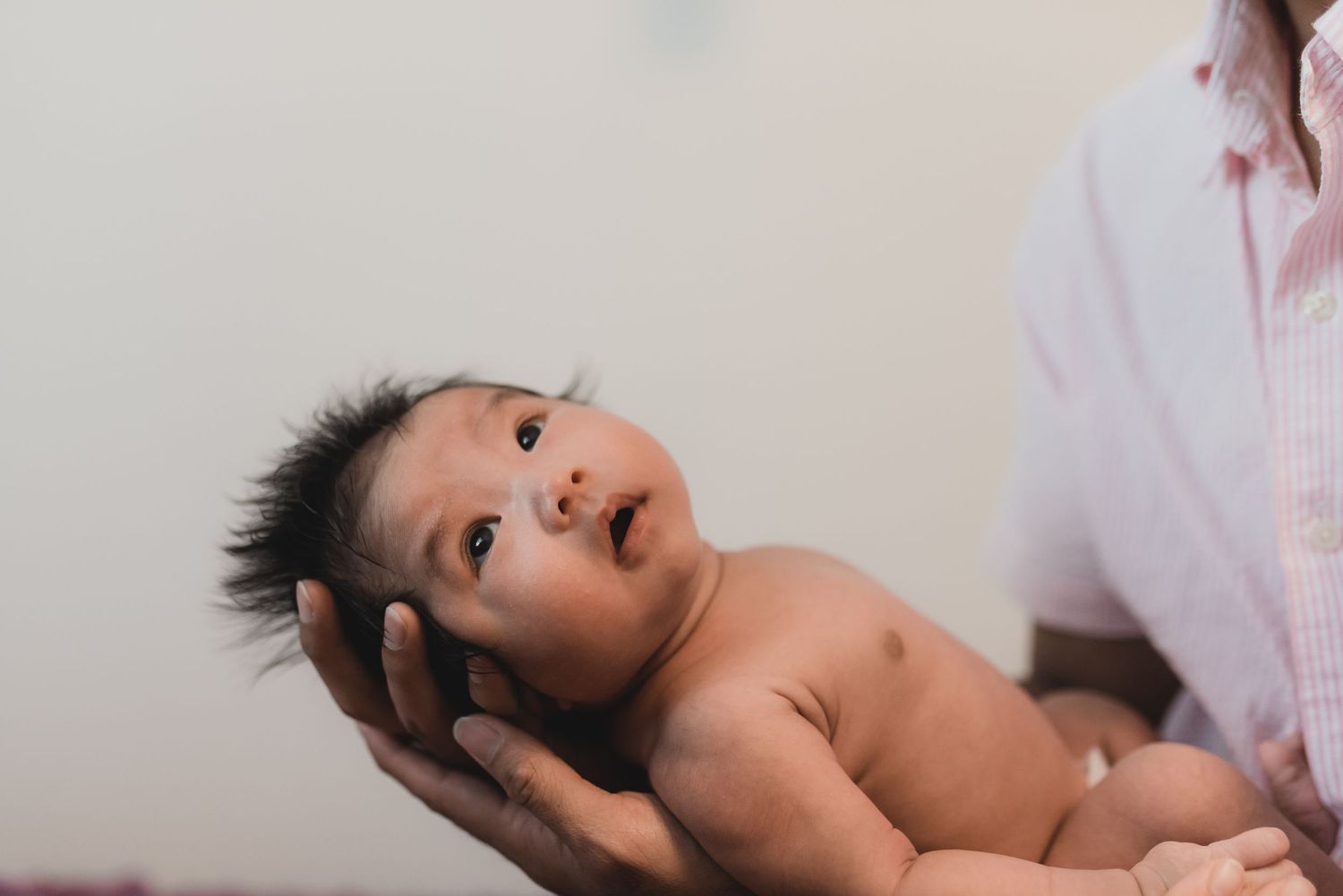 Sweet newborn photography session with baby lying on white blankets.